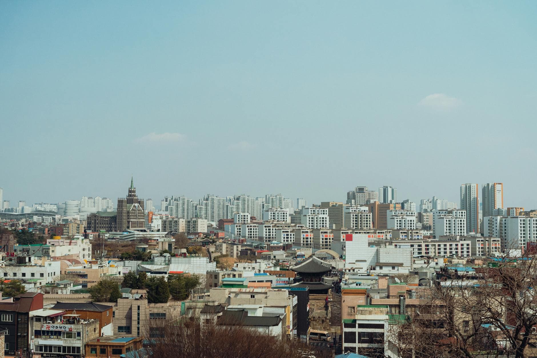 Explore a panoramic view of Seoul's modern skyline with historic architecture under a clear blue sky.
