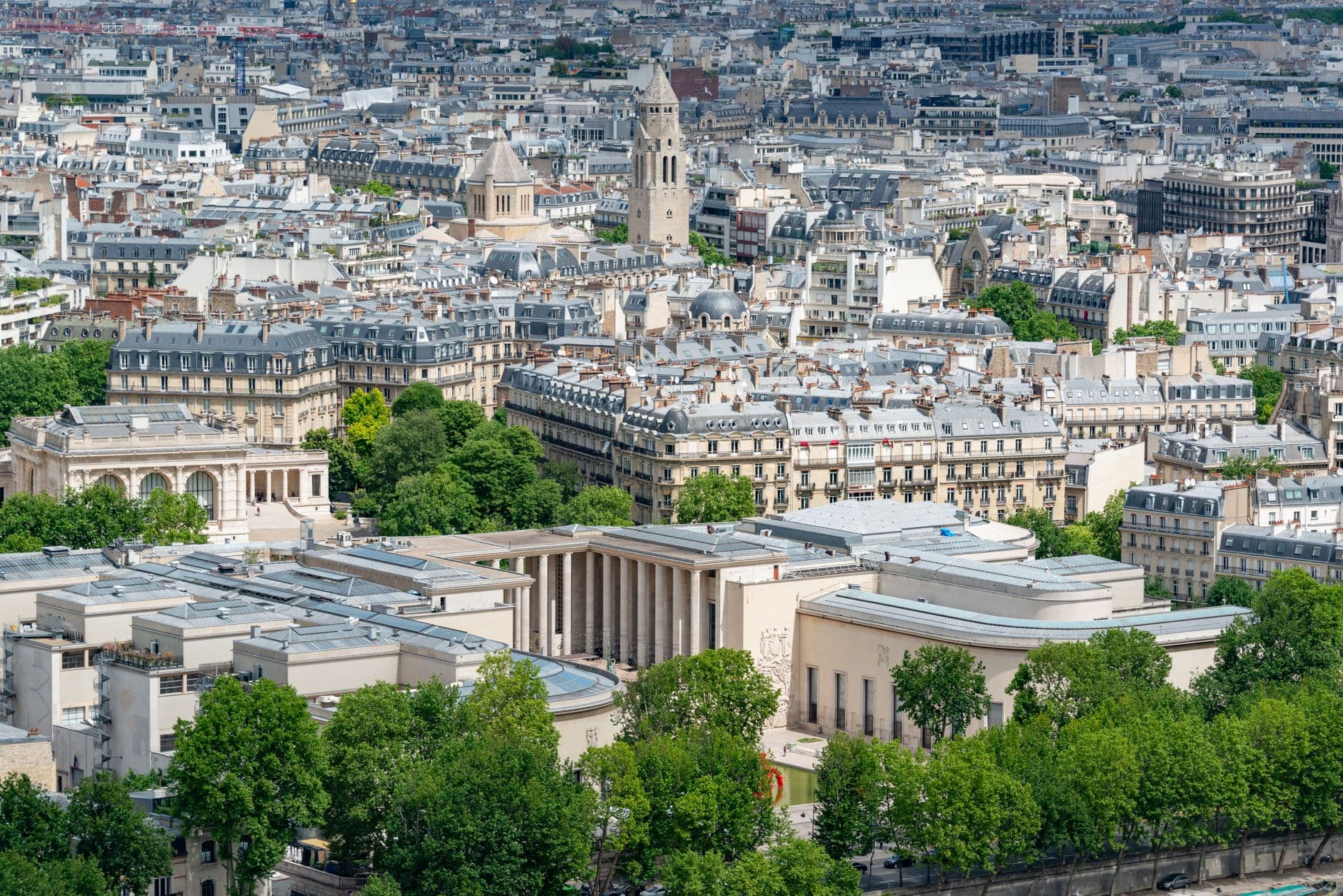 A stunning aerial view of Paris highlighting historic architecture and lush greenery.