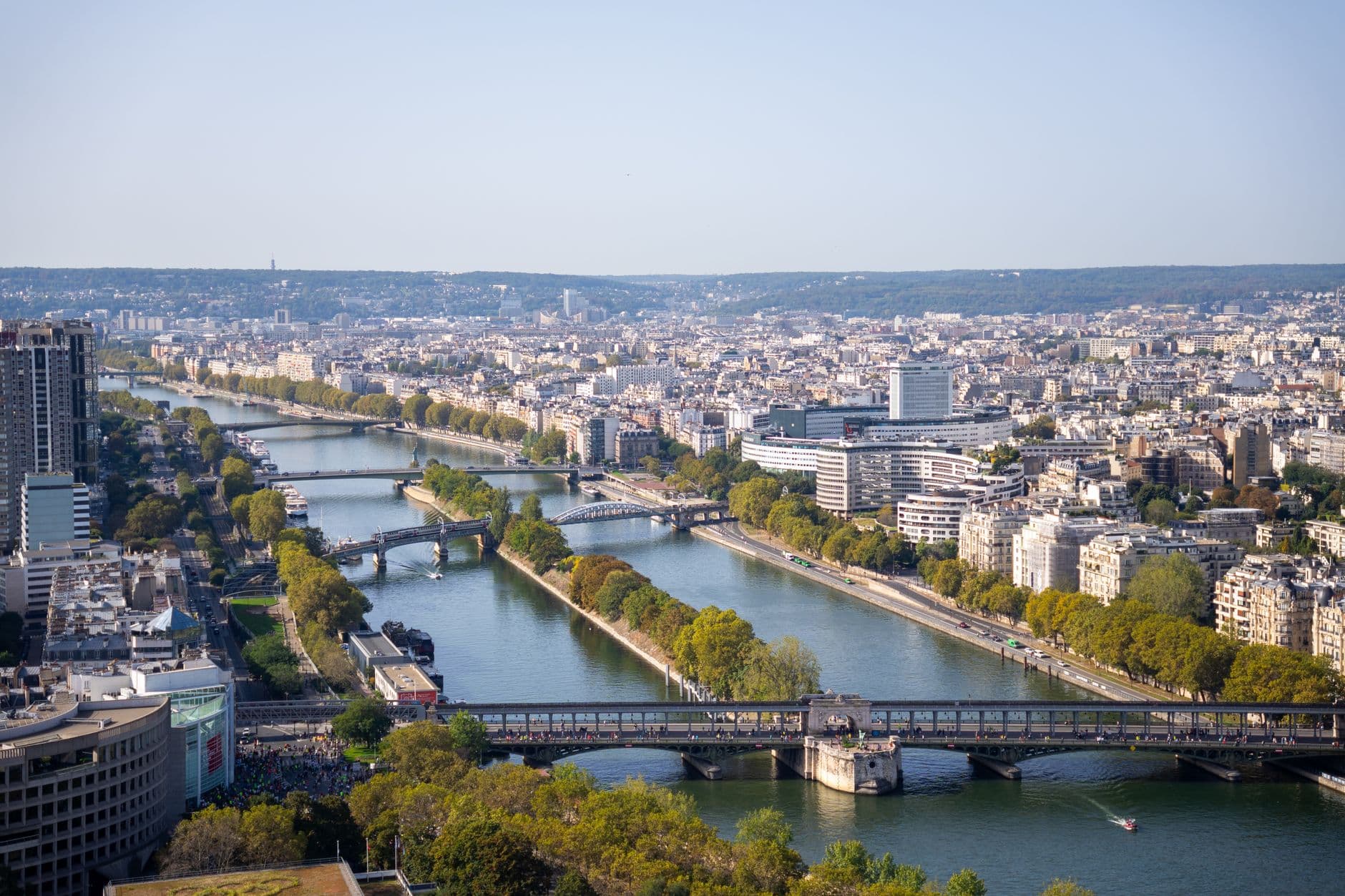A panoramic aerial view capturing the Seine River and bridges in Paris, France.