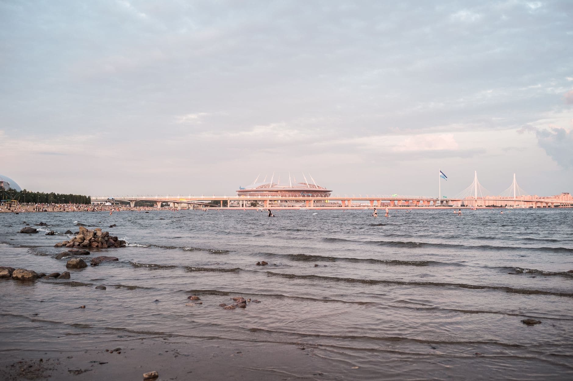 A beautiful view of Saint Petersburg's waterfront with a stadium and bridge at sunset.