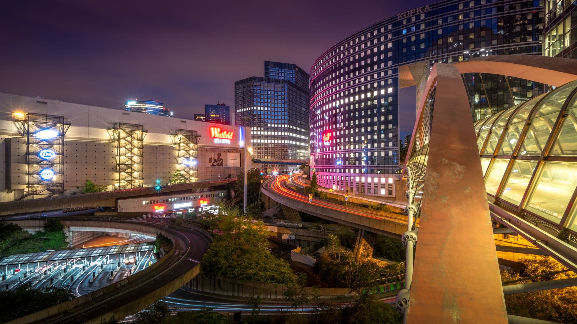 Stunning nighttime view of the La Défense district in Paris, France, showcasing modern skyscrapers and urban lights.