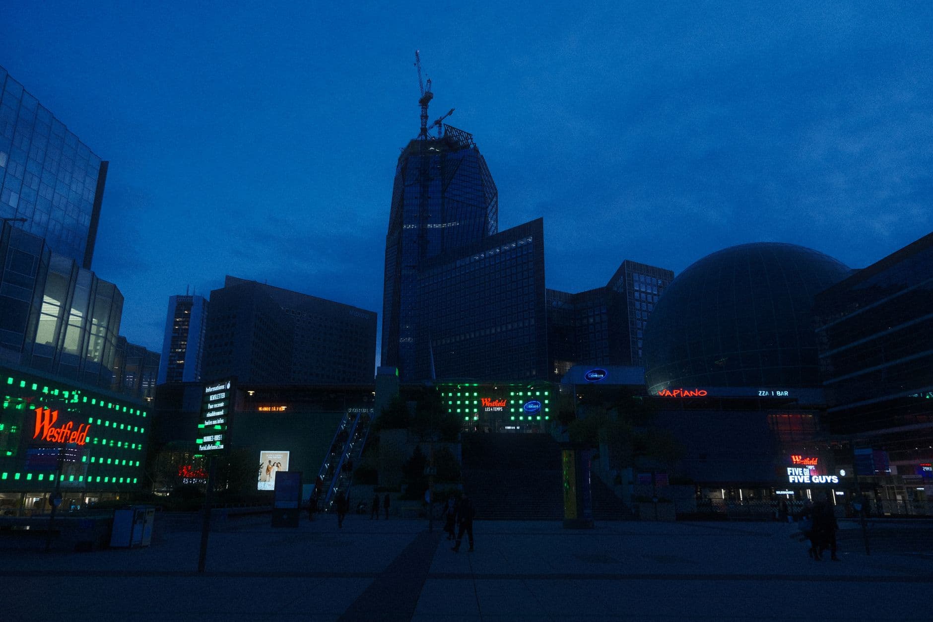 Illuminated urban skyline featuring modern architecture and vibrant city life at night.