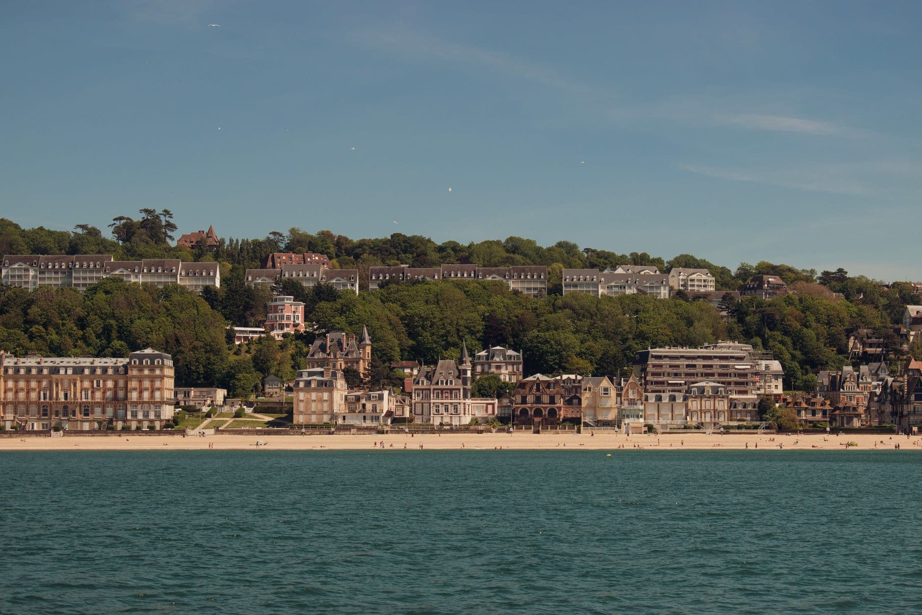 Scenic view of Trouville-sur-Mer beach and charming architecture in Normandy, France under a clear blue sky.