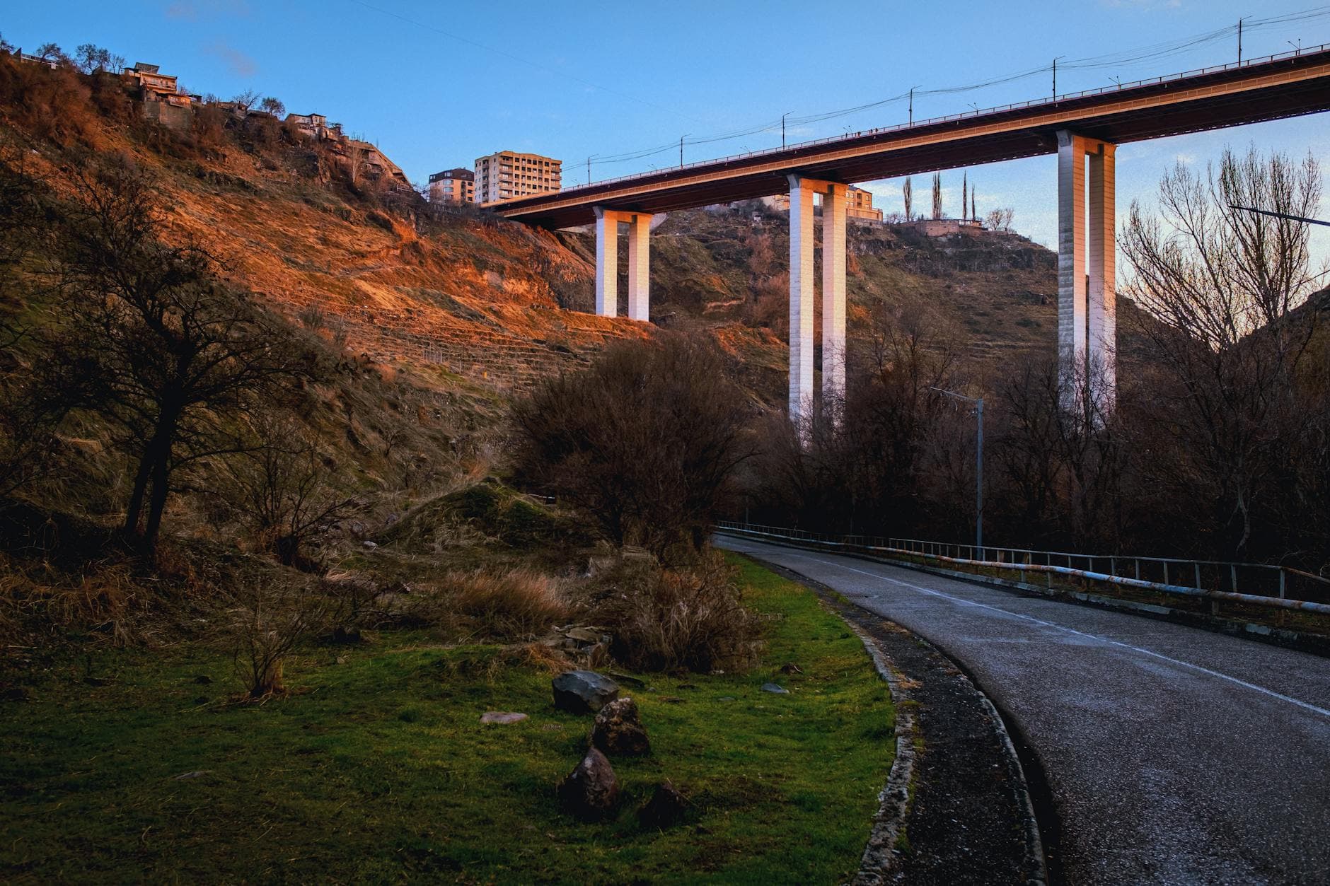 A stunning view of a bridge over a rugged landscape at sunset, capturing serene natural beauty.