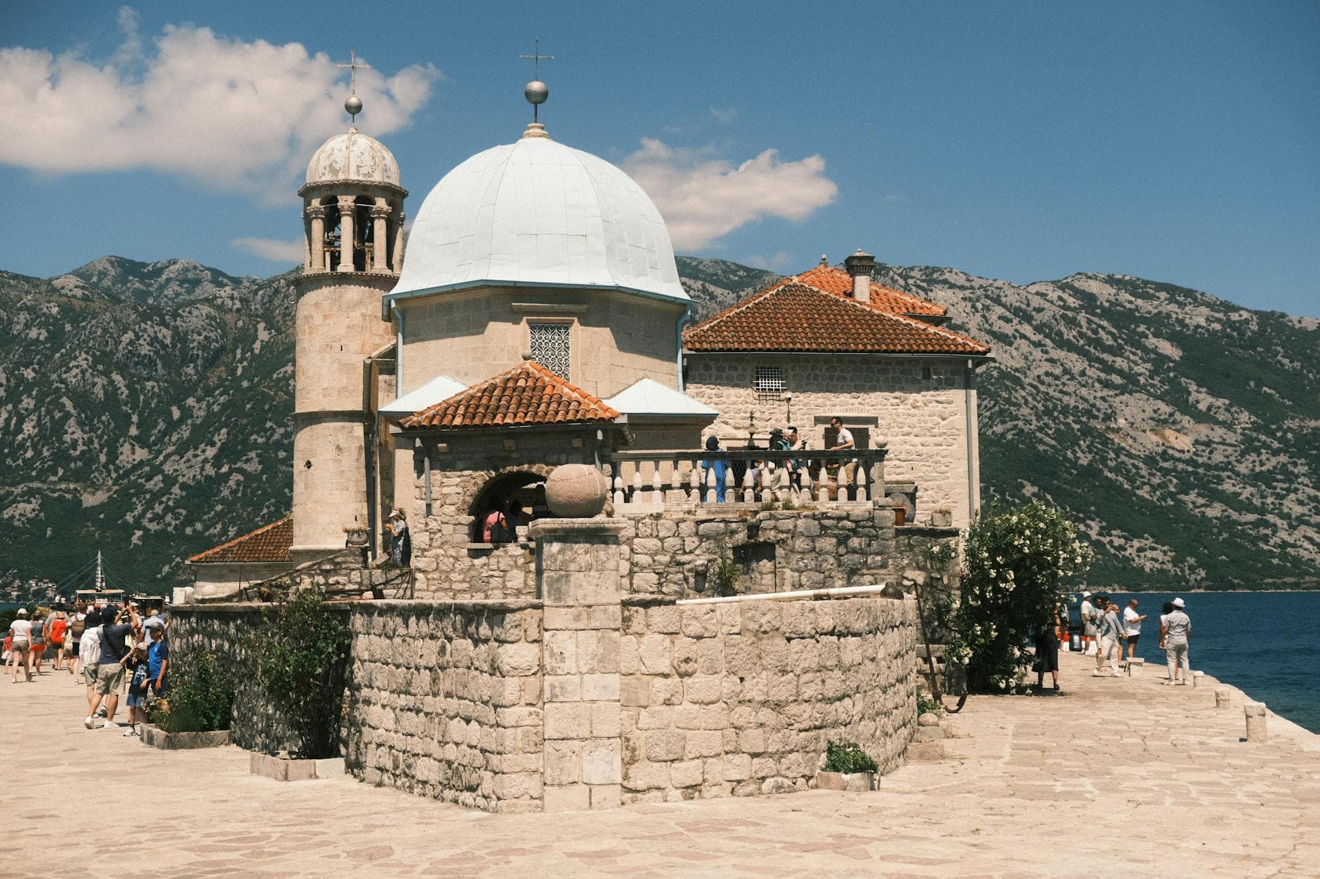 Explore the historic Our Lady of the Rocks church in Perast, Montenegro, nestled in the Bay of Kotor.