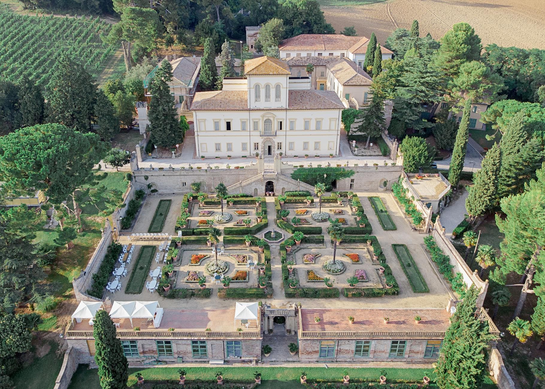 Picturesque aerial view of historic Villa Caprile built in Baroque style with well groomed symmetric garden surrounded by lush green trees in Pesaro