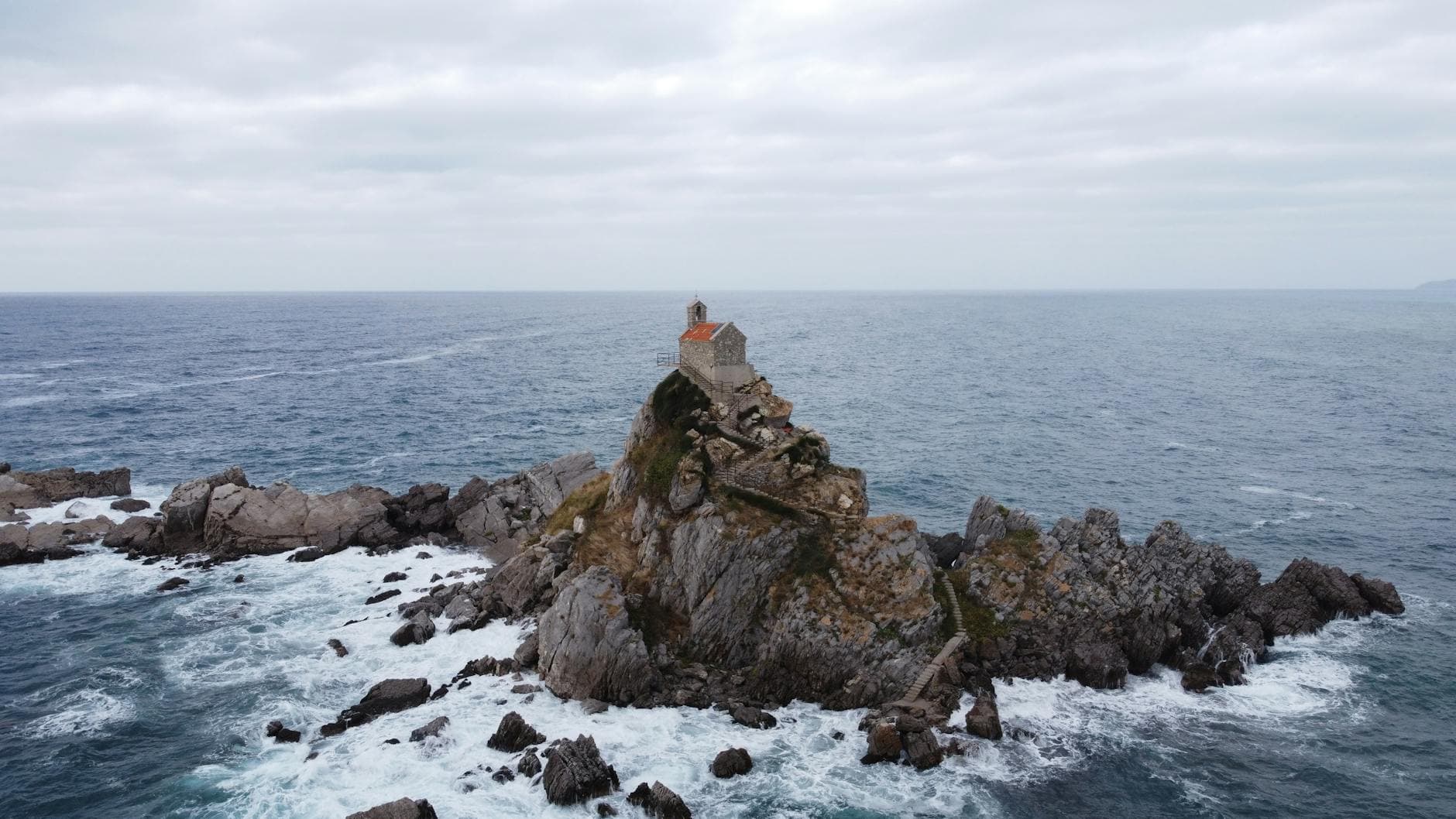 Aerial view of St. Nedjelja Church on a rocky island off the coast of Montenegro.
