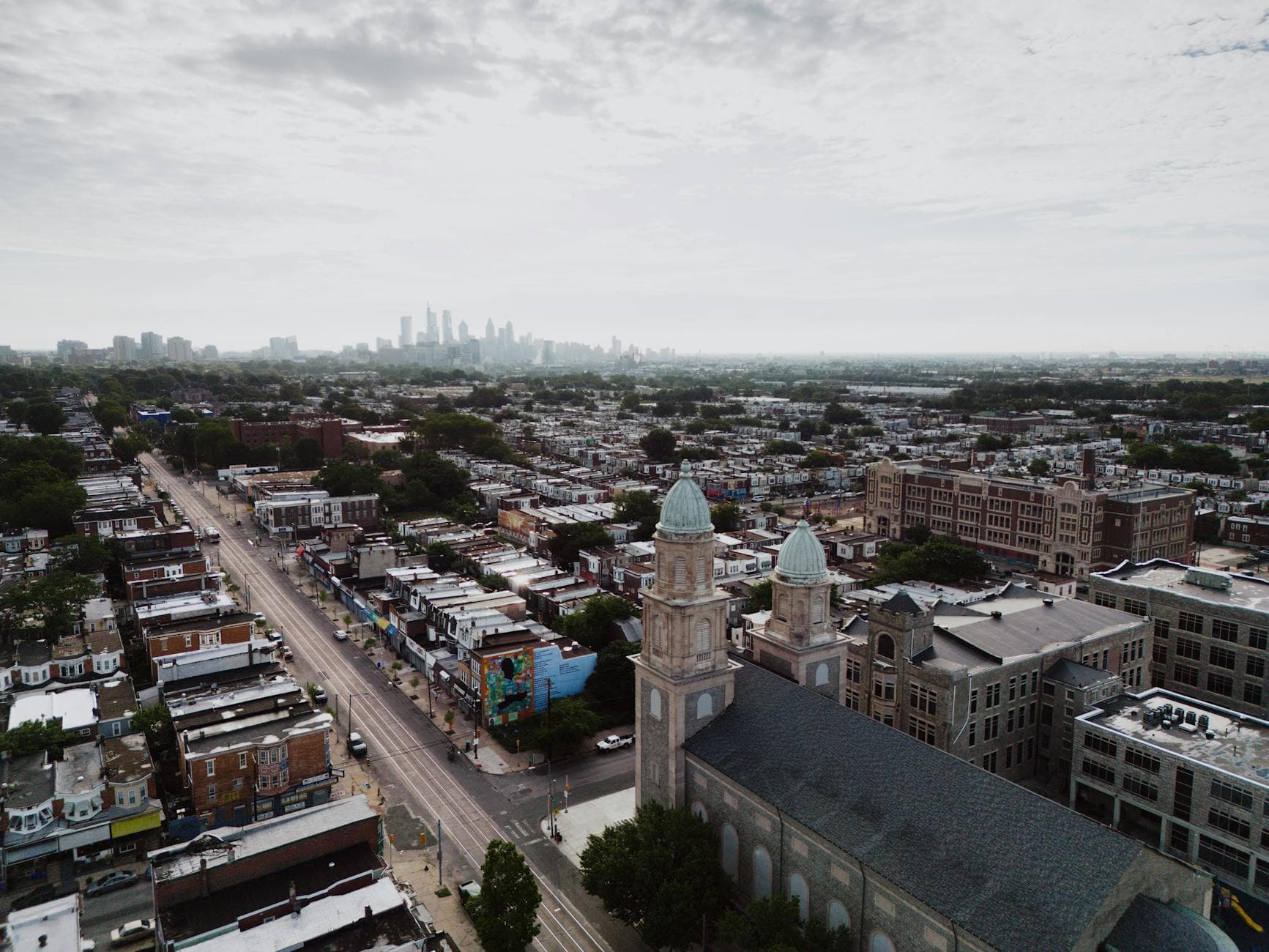 Aerial view showcasing Philadelphia's skyline and urban landscape with a historic church in the foreground.