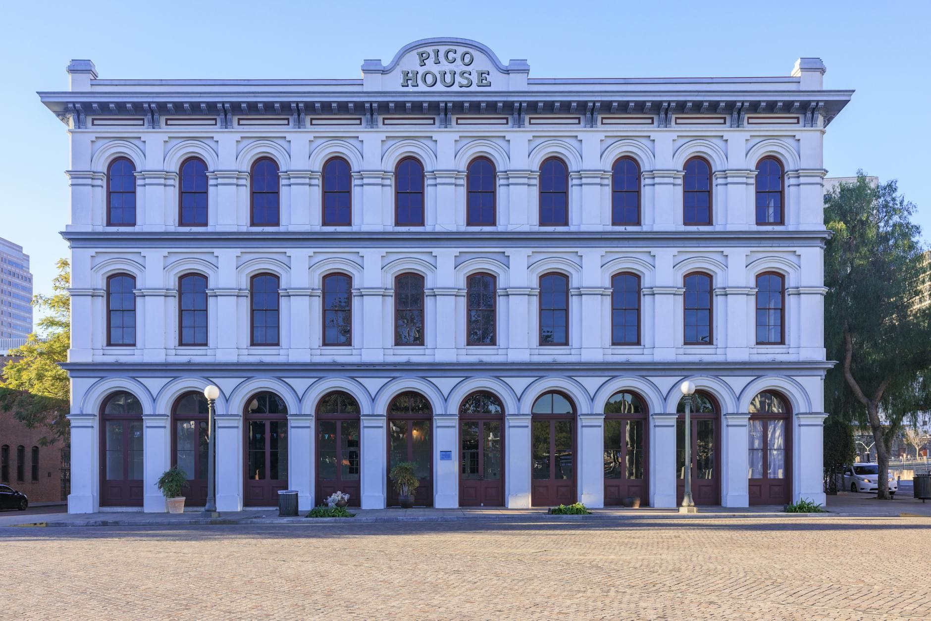 A historic front view of Pico House in Los Angeles under clear skies.