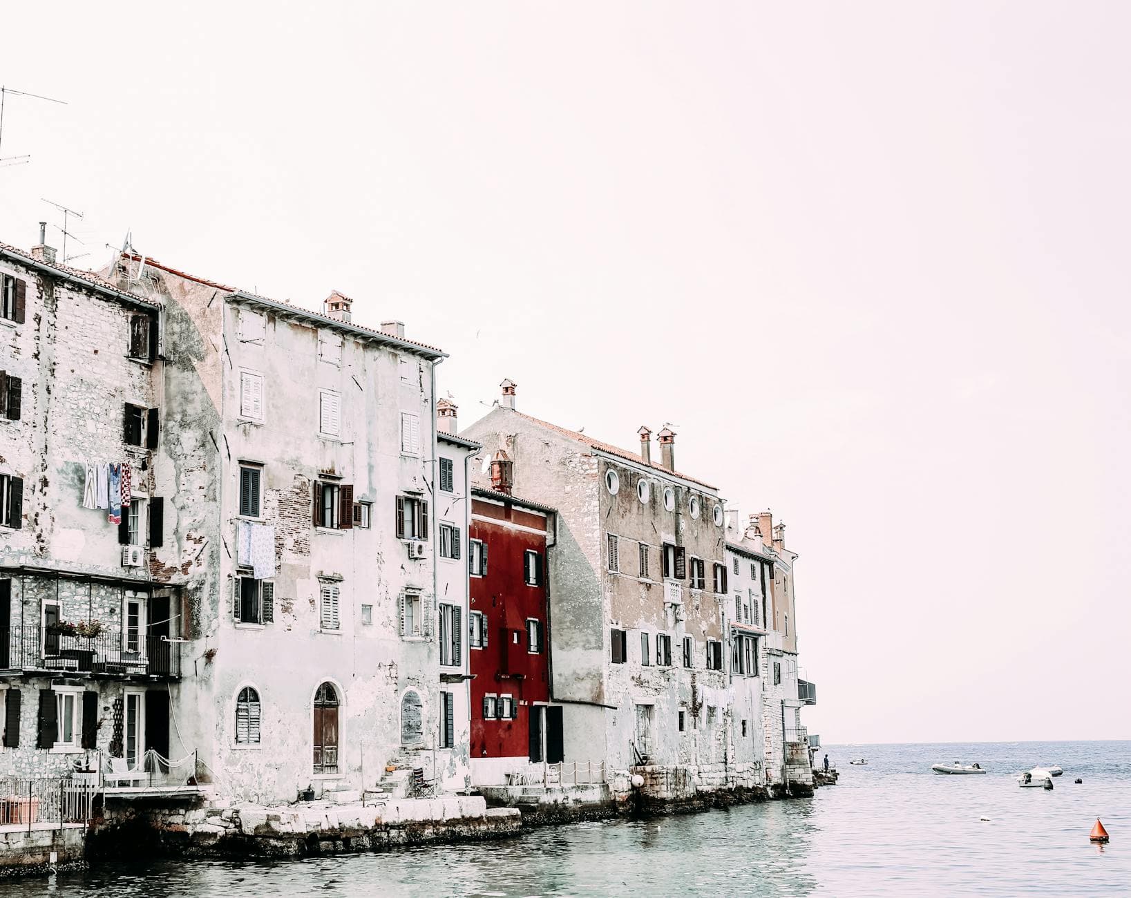 View of weathered historic buildings by the sea, exuding a tranquil coastal charm.