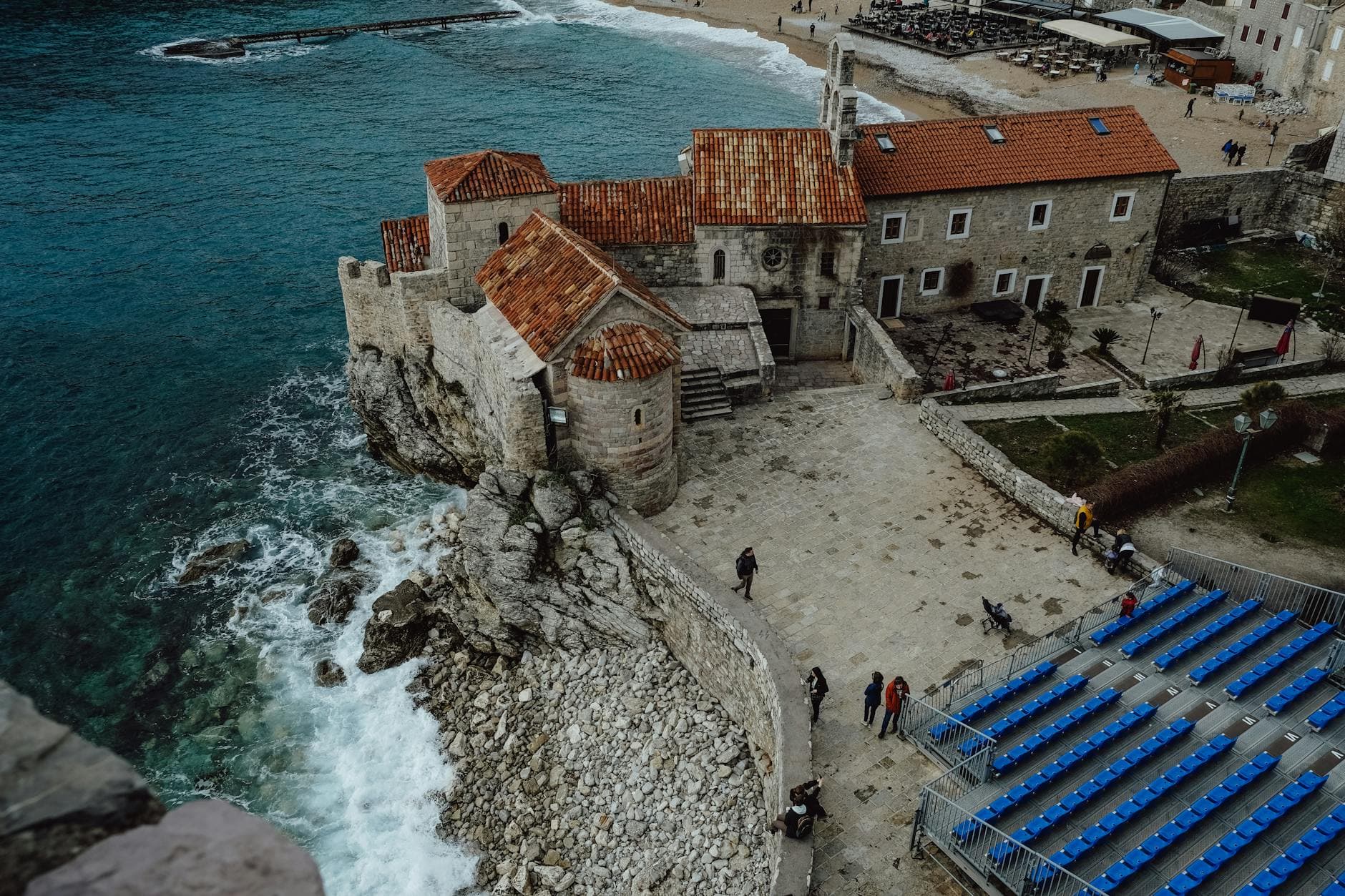 A stunning aerial shot of the historical Budva Old Town with its stone architecture against the Adriatic Sea.