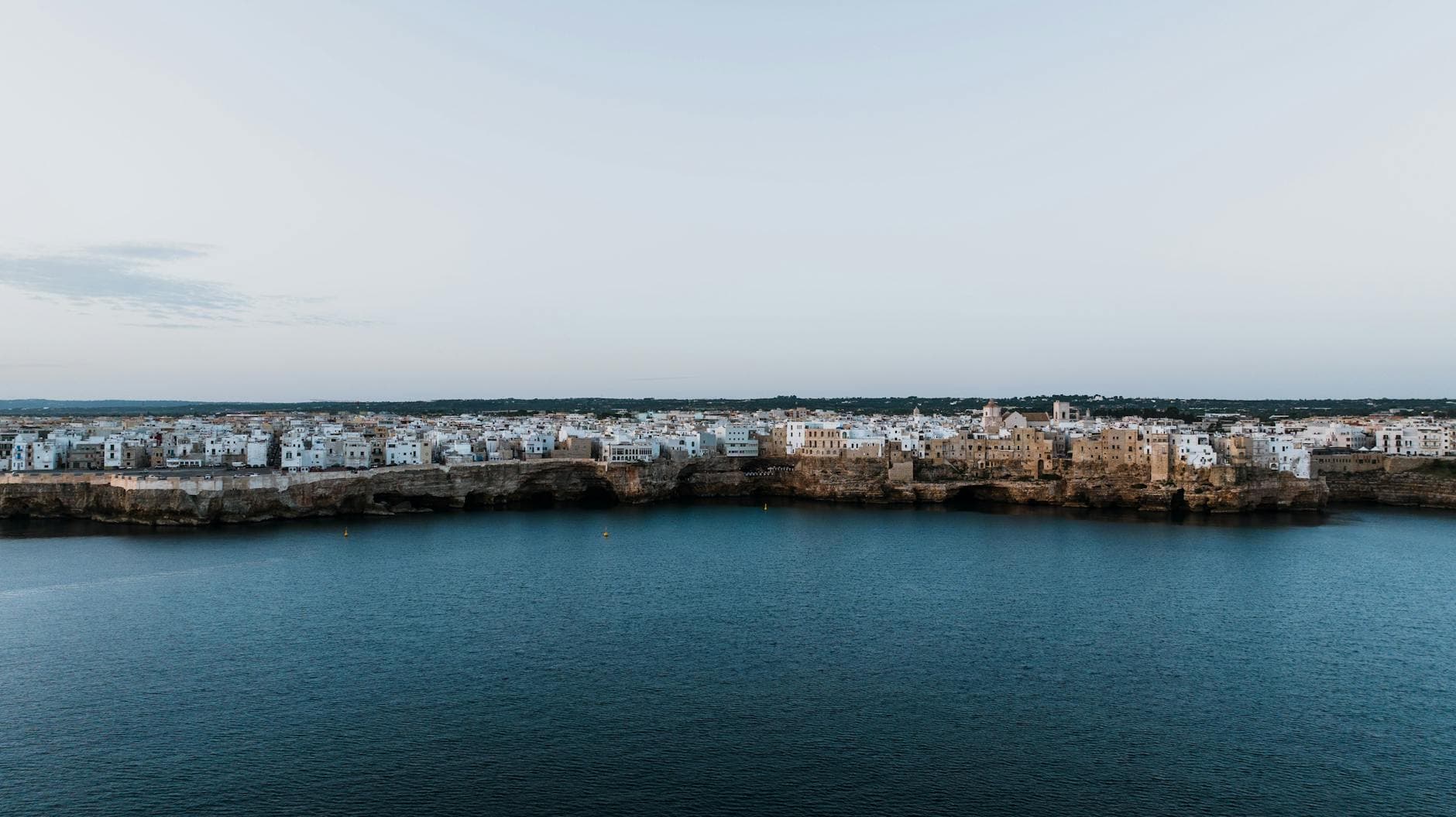 A stunning aerial view of Polignano a Mare, Italy, showcasing its cliffside architecture by the sea.
