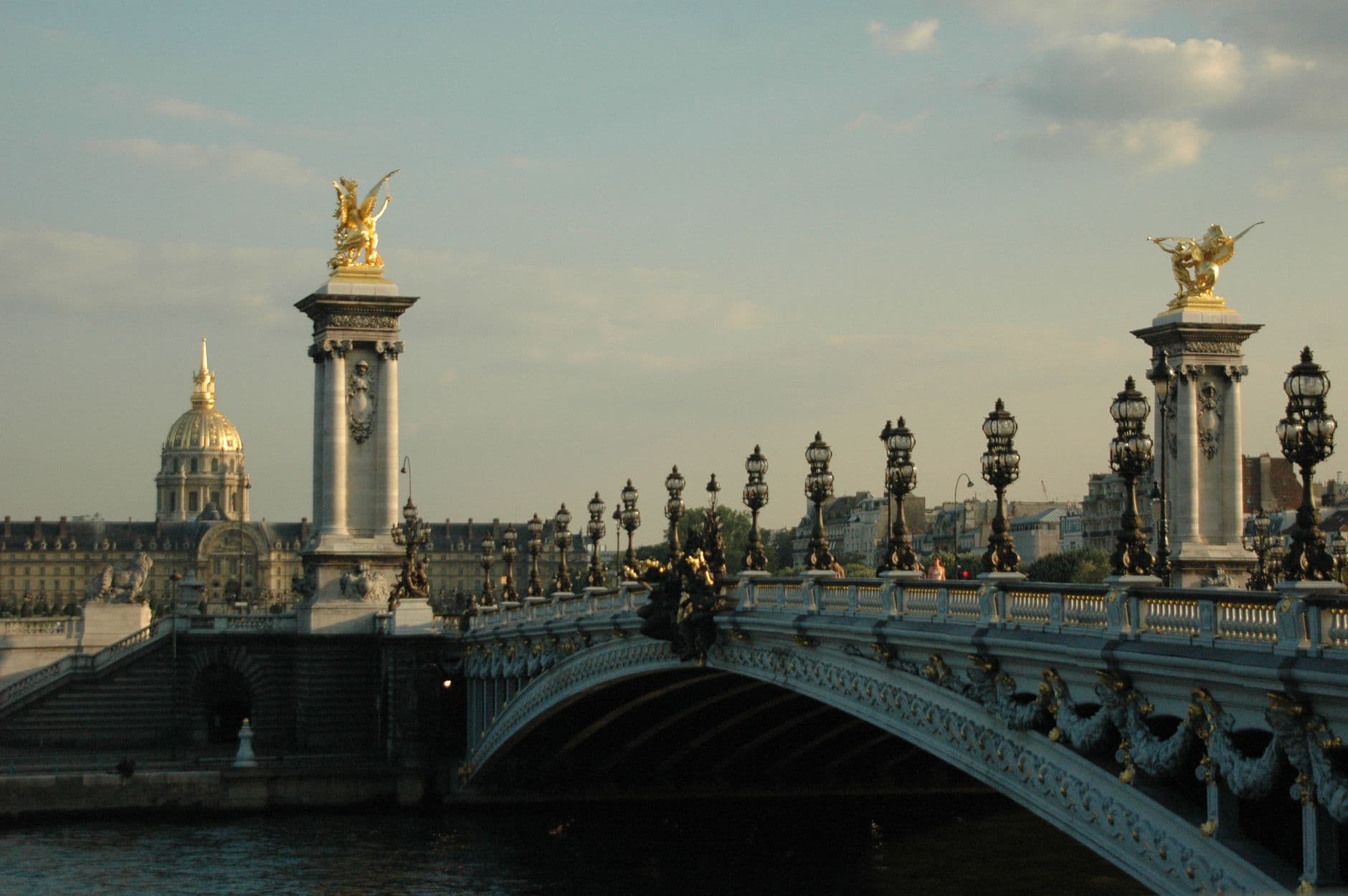 Stunning view of the historic Pont Alexandre III bridge in Paris with its iconic sculptures and streetlights.