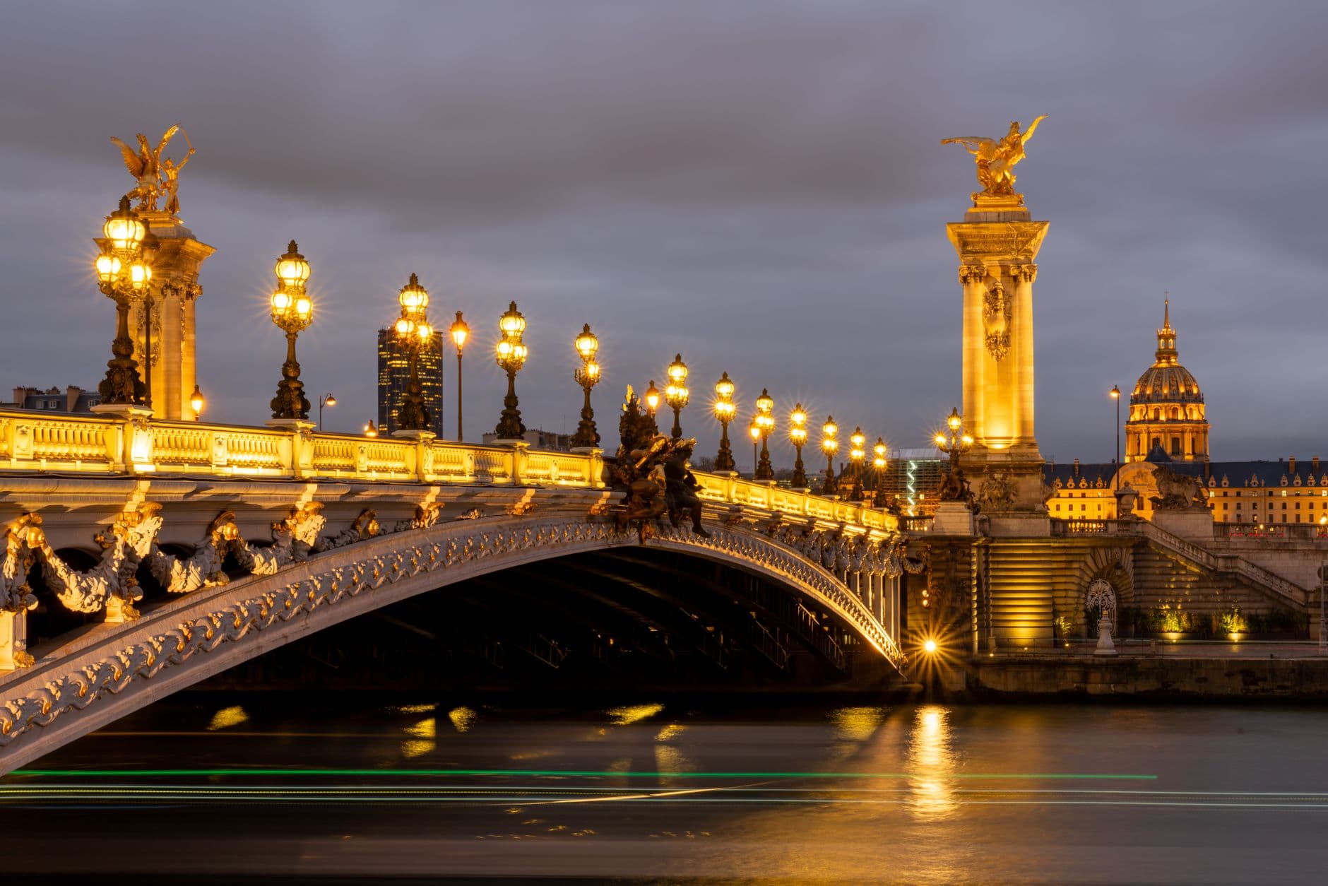Majestic view of the illuminated Pont Alexandre III bridge in Paris at night, a true architectural masterpiece.