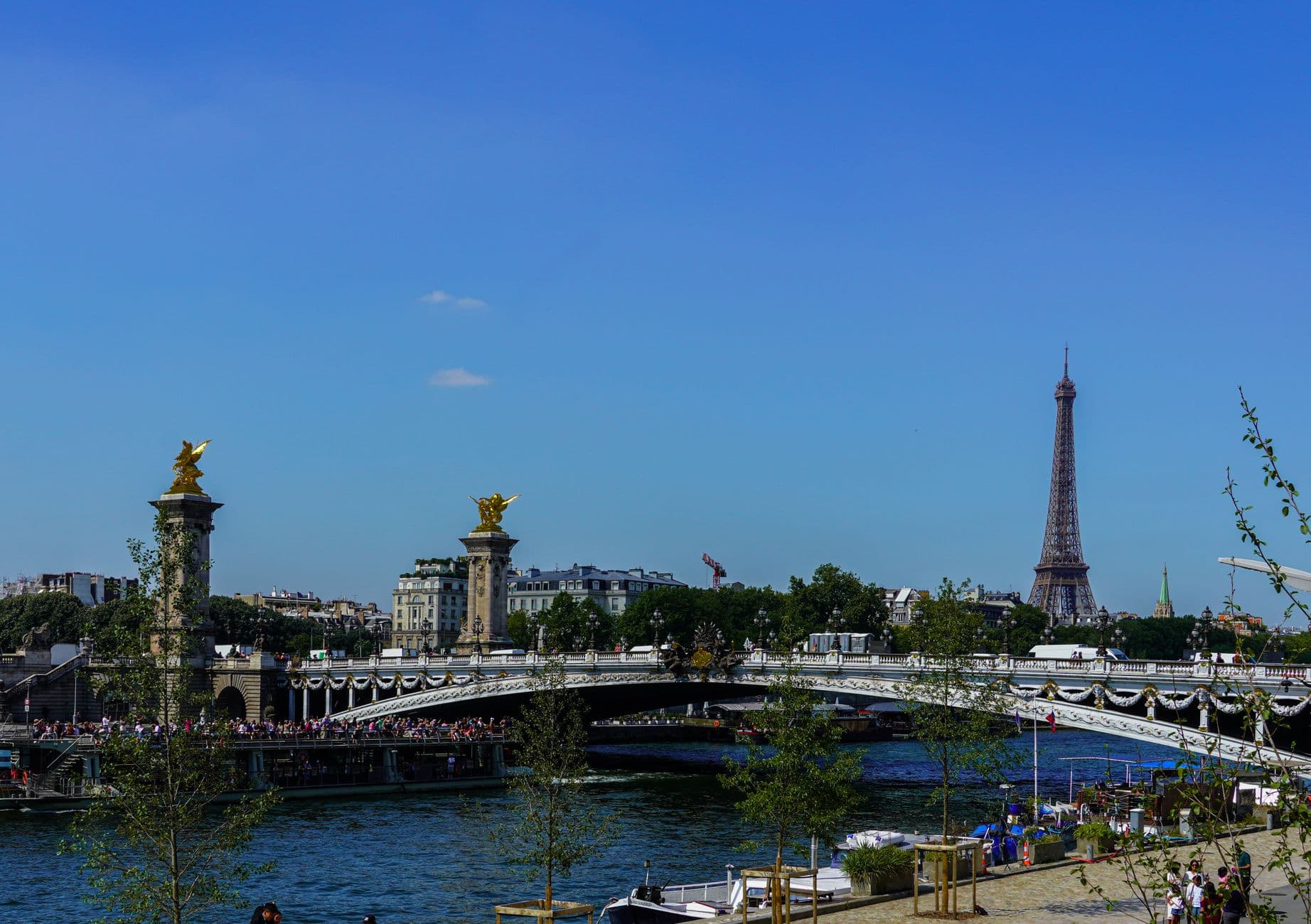 Scenic view of Eiffel Tower and Seine River with Pont Alexandre III on a sunny day in Paris, France.