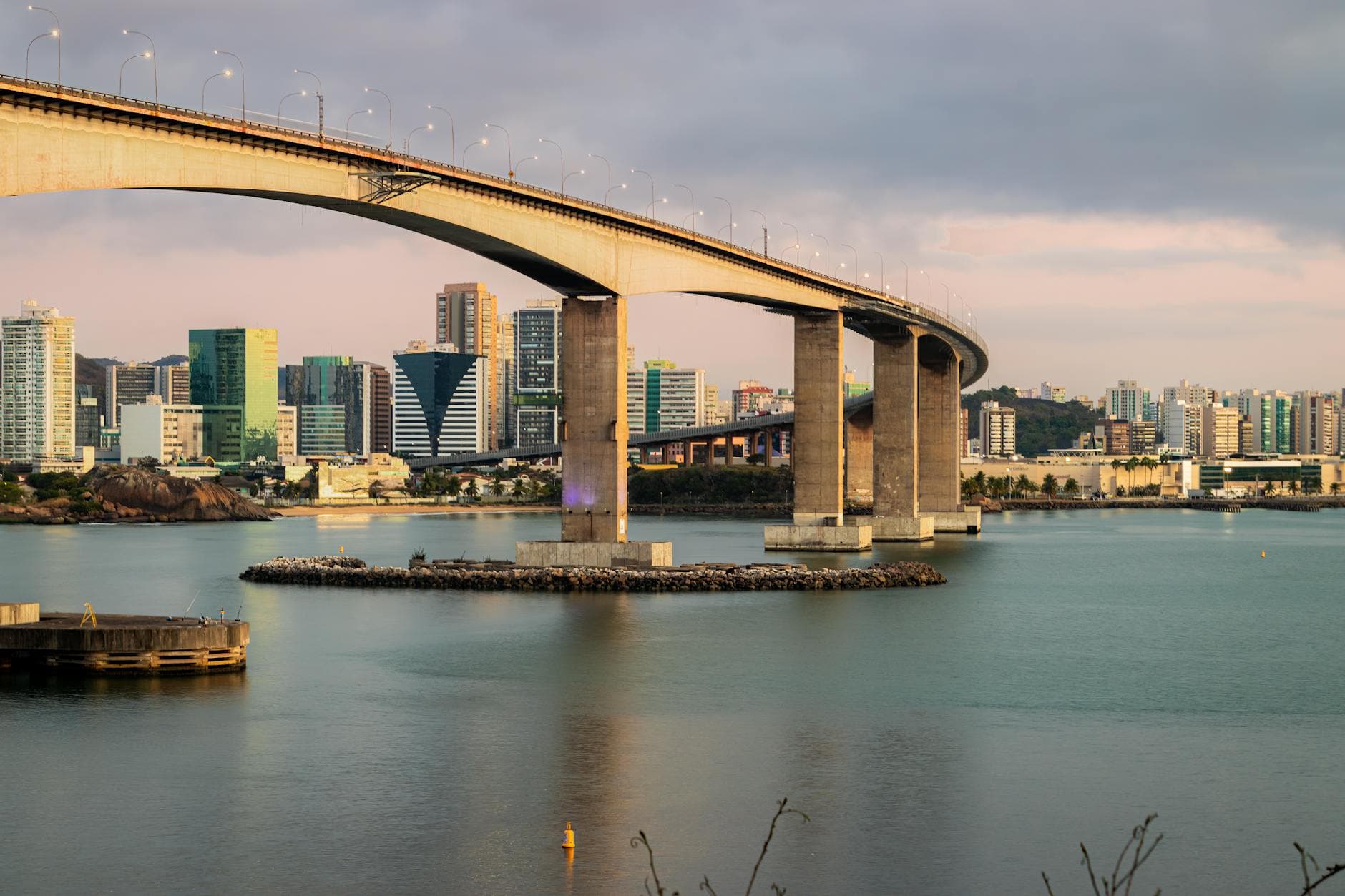 Beautiful sunset over Third Bridge in Vitória, Brazil, with cityscape and water reflections.