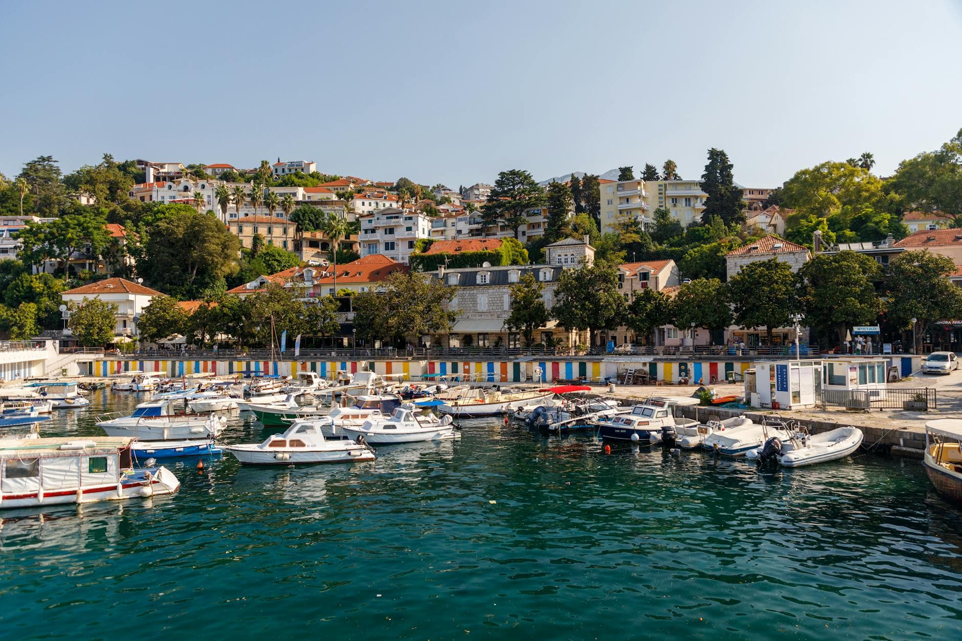 Serene marina view with boats and colorful waterfront in Herceg Novi, Montenegro.