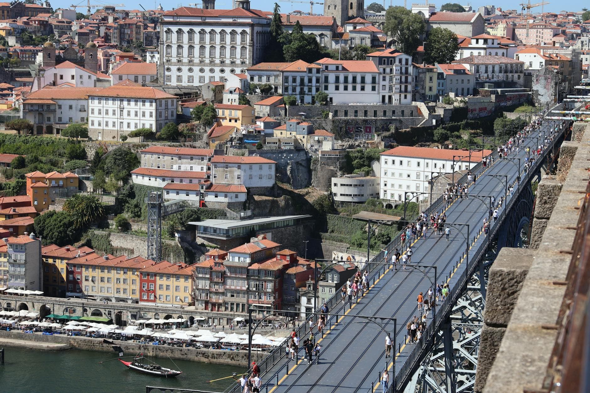 A bustling aerial view of Dom Luís I Bridge and historic Porto with vibrant buildings.