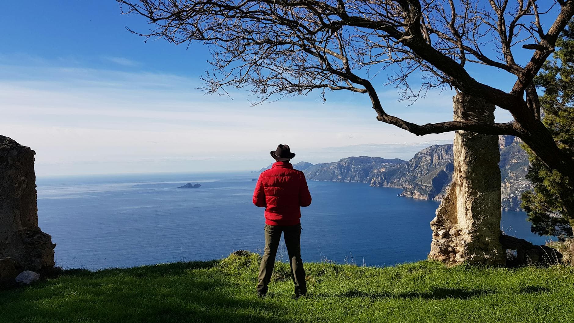 Enjoy a serene coastal view from Praiano, Italy, with a lone hiker in a scenic landscape.