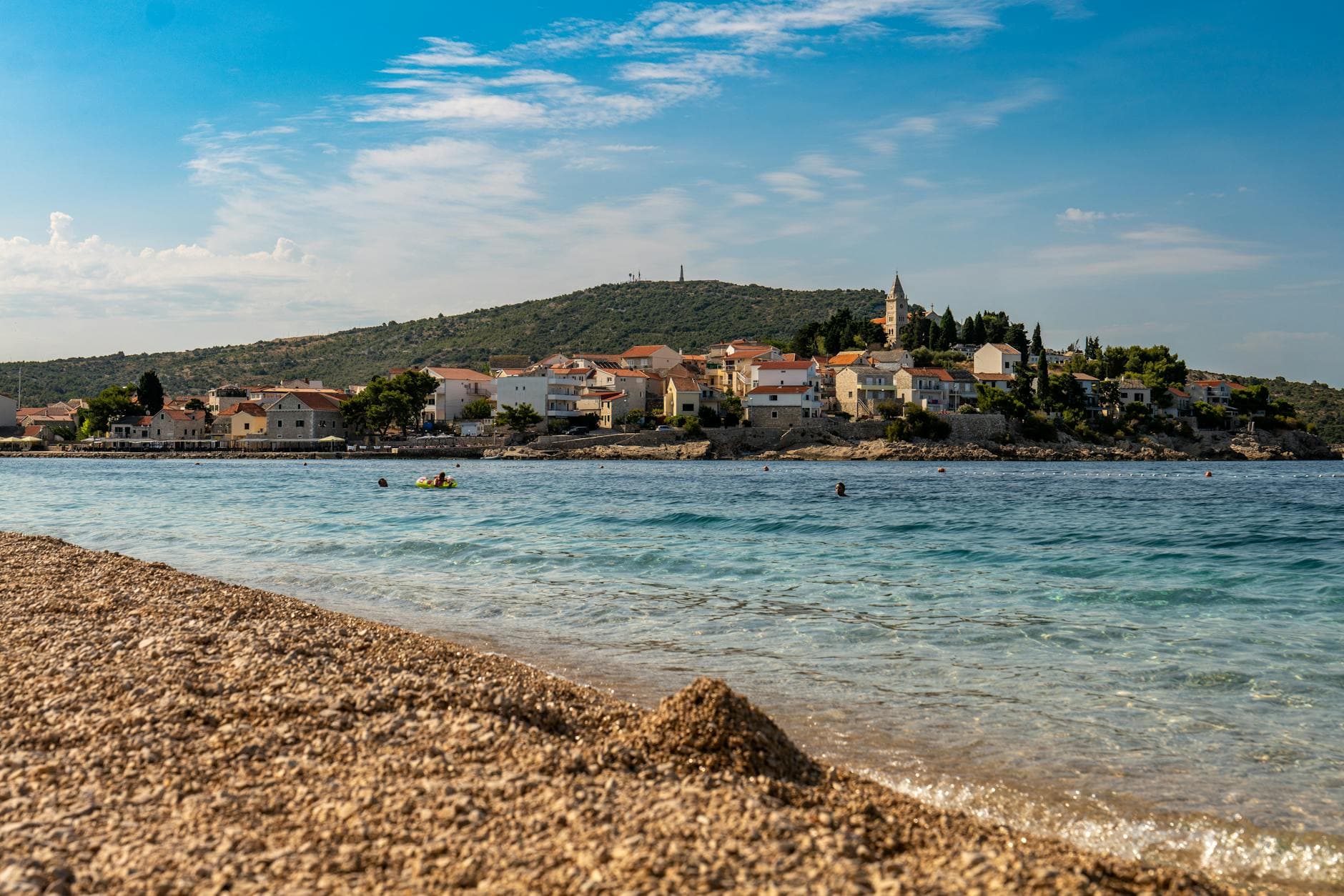 A stunning view of Primošten beach with sparkling waters and charming architecture.