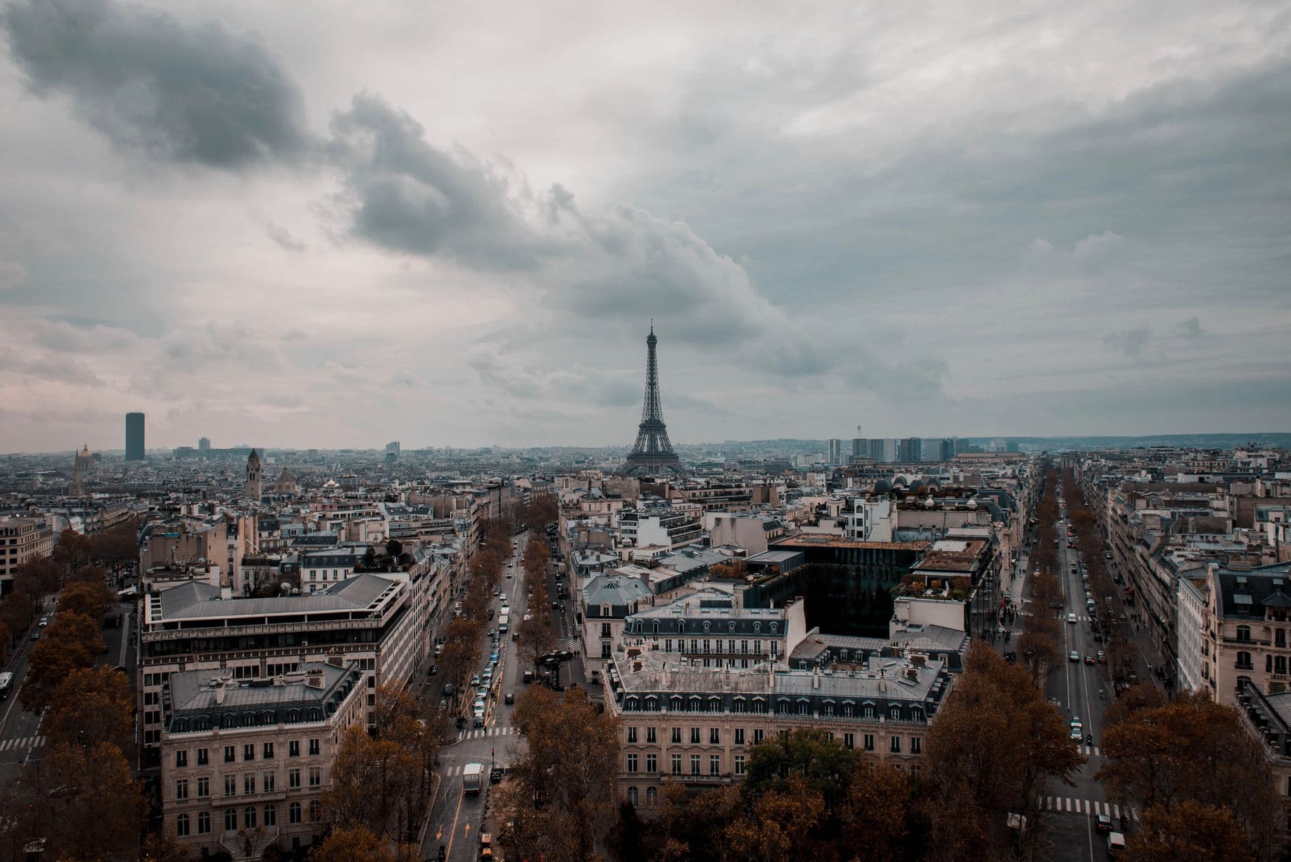 A stunning aerial view of Paris showcasing the iconic Eiffel Tower under cloudy skies.