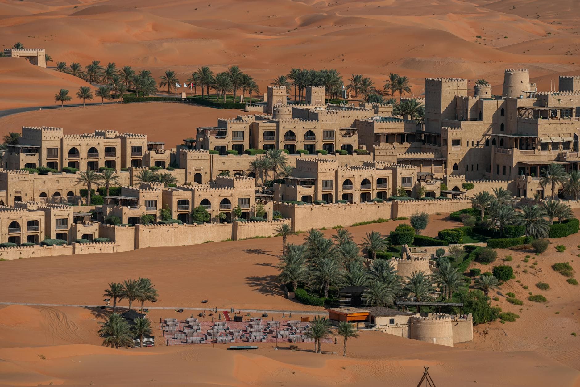 Aerial view of a luxurious resort amidst the Abu Dhabi desert, showcasing traditional architecture.