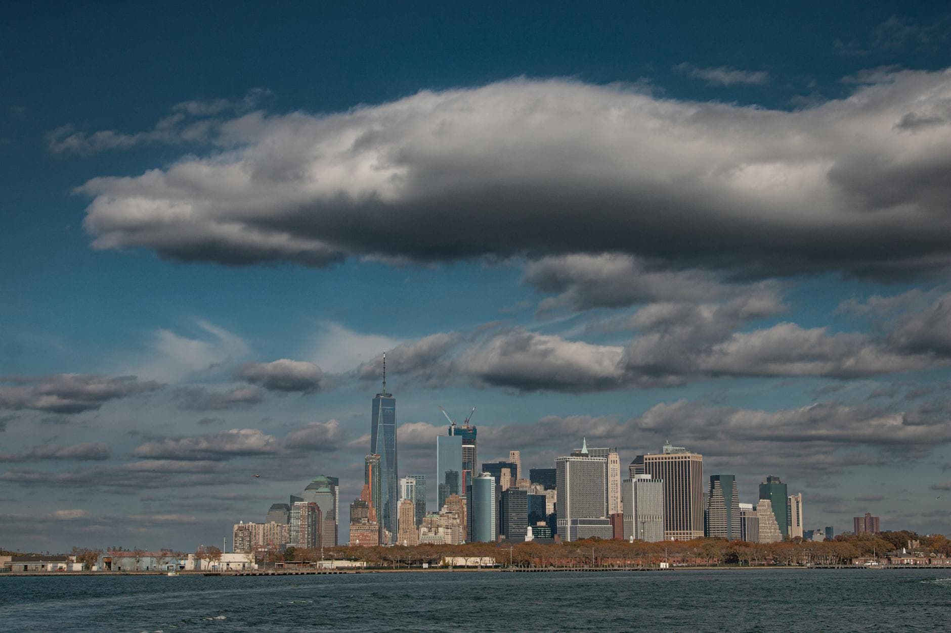 Dynamic view of New York City's skyline under dramatic clouds, captured in daylight.