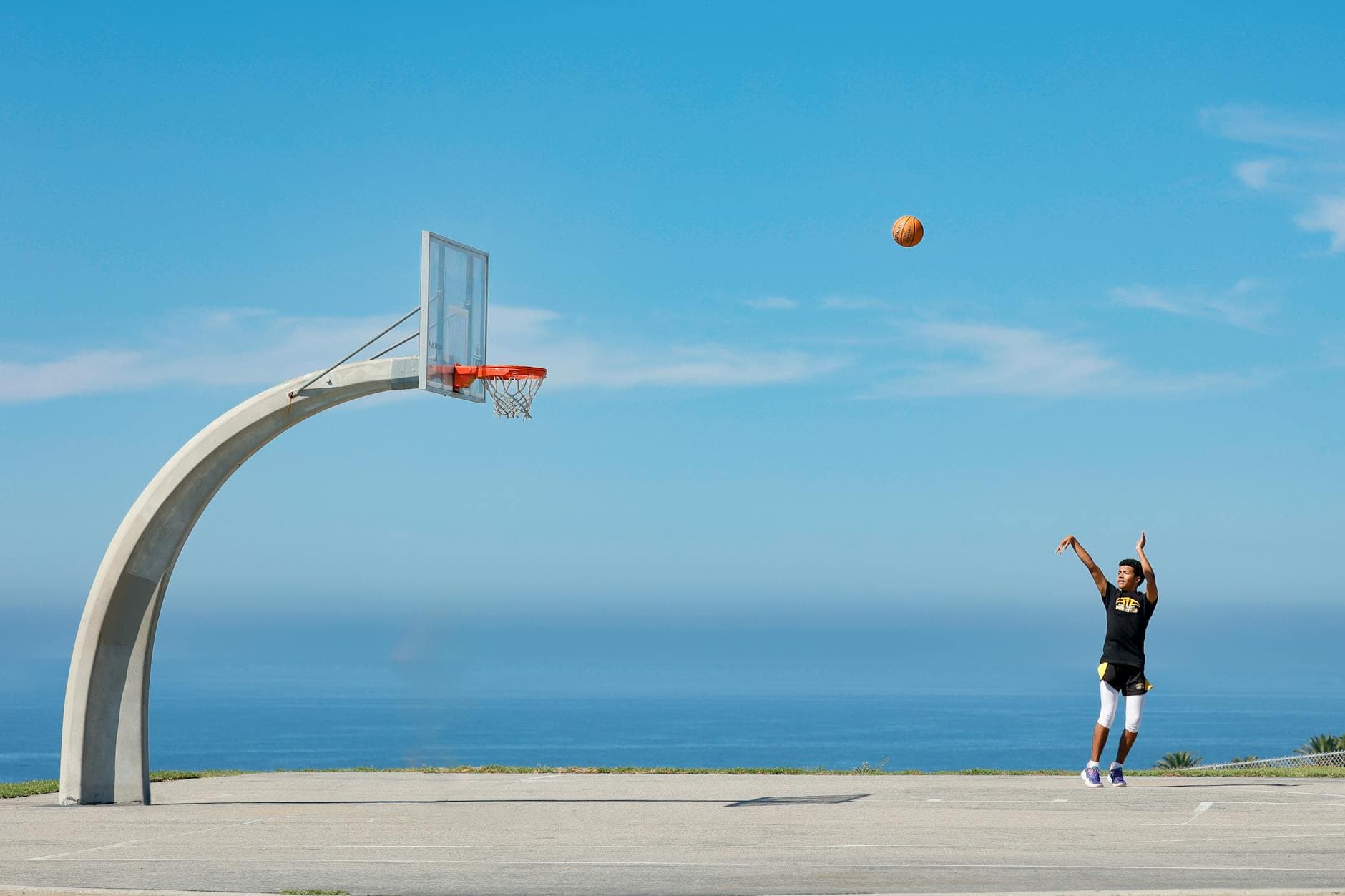 Athlete practicing basketball jumpshot on outdoor court overlooking the ocean in Rancho Palos Verdes.