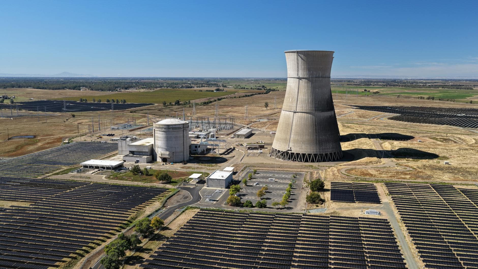 Aerial shot of Rancho Seco Solar Power Plant with large cooling tower and solar panels.