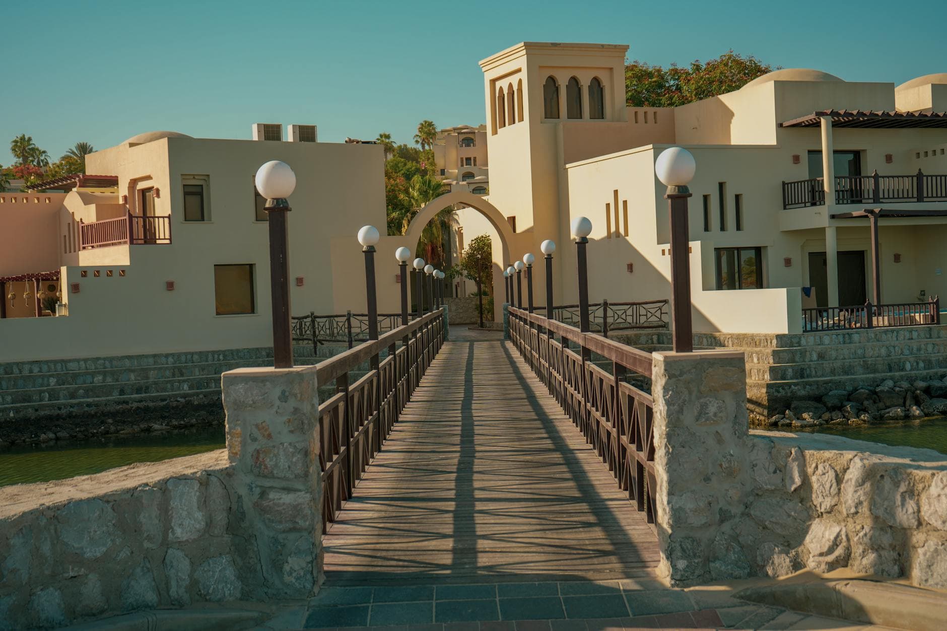 Elegant residential villa in Ras Al Khaimah, United Arab Emirates, with a scenic archway and footbridge.