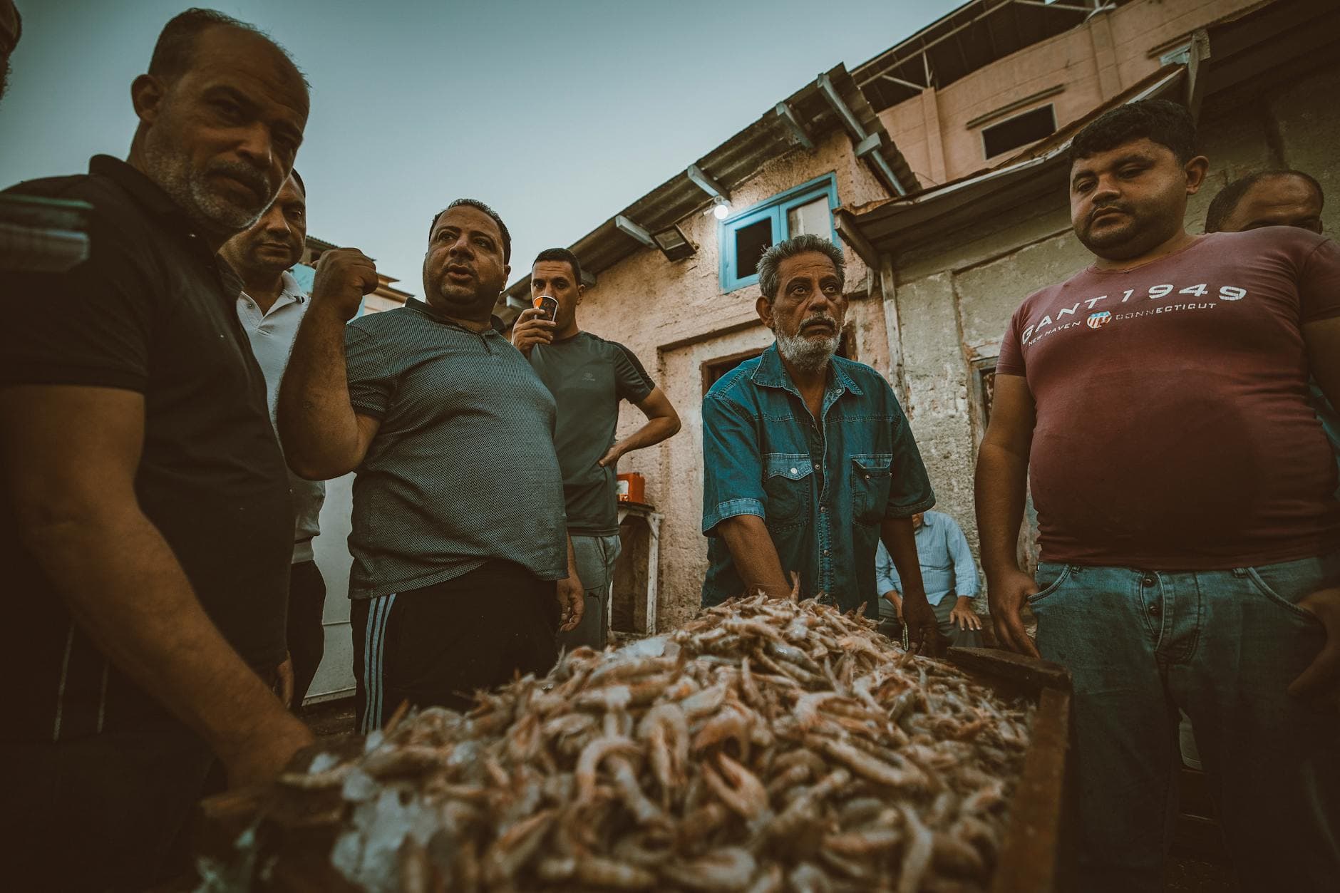 A lively street scene at a fish market in Ras El-Bar, showcasing local fishermen and their catch.