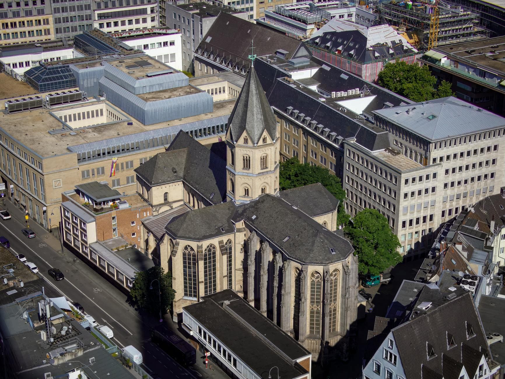 Aerial shot of a historic church surrounded by modern urban buildings.