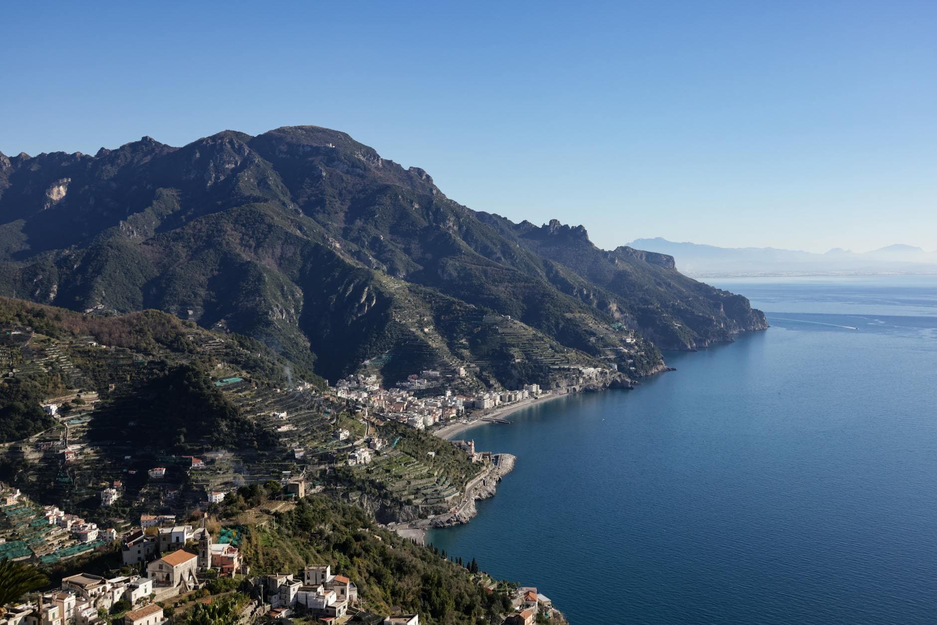 A breathtaking aerial view of the Amalfi Coast's rugged mountains meeting the pristine Mediterranean Sea.