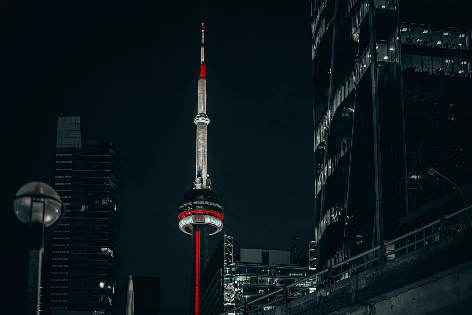 Stunning night view of the illuminated CN Tower in downtown Toronto, capturing urban elegance.