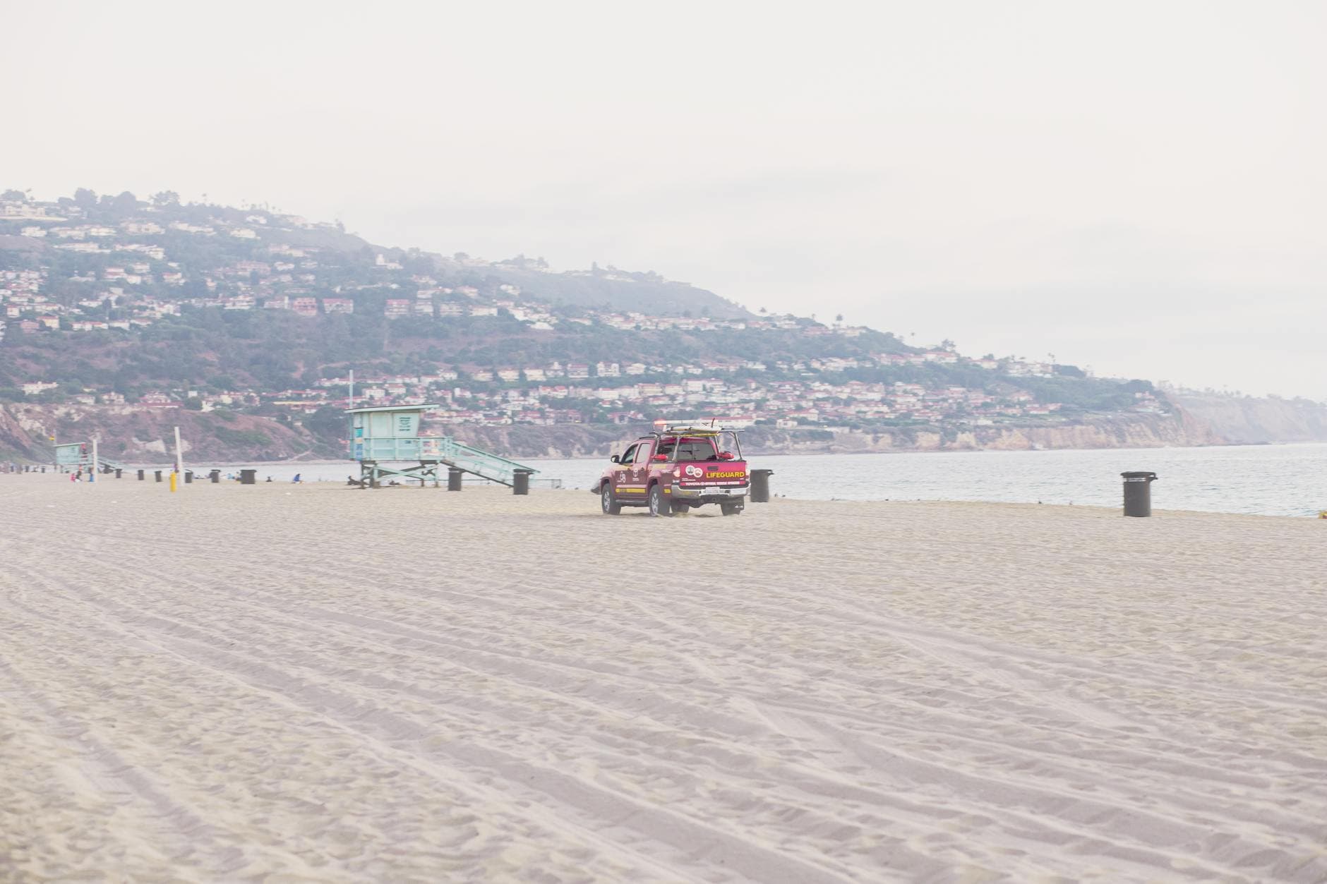 A sunny day at Redondo Beach with a lifeguard tower and pickup truck on the sand.