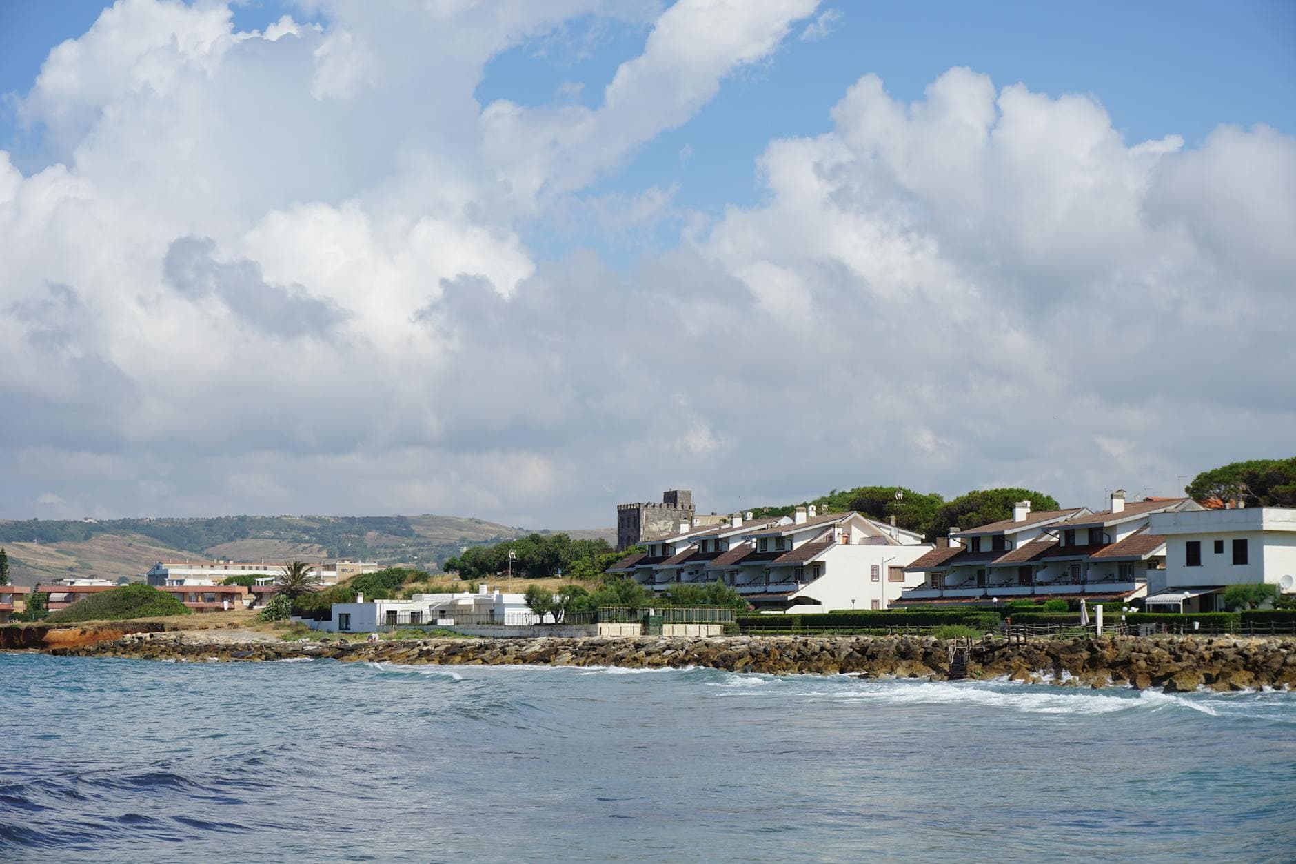 Captivating coastal image of Santa Severa, Italy, with villas and a castle under a blue sky.