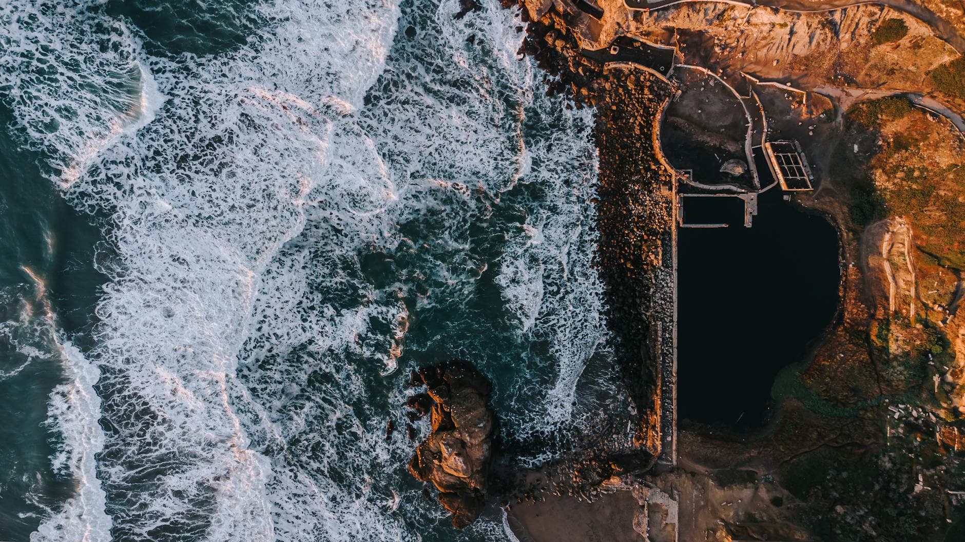 Breathtaking aerial shot capturing waves crashing against the San Francisco coastline.