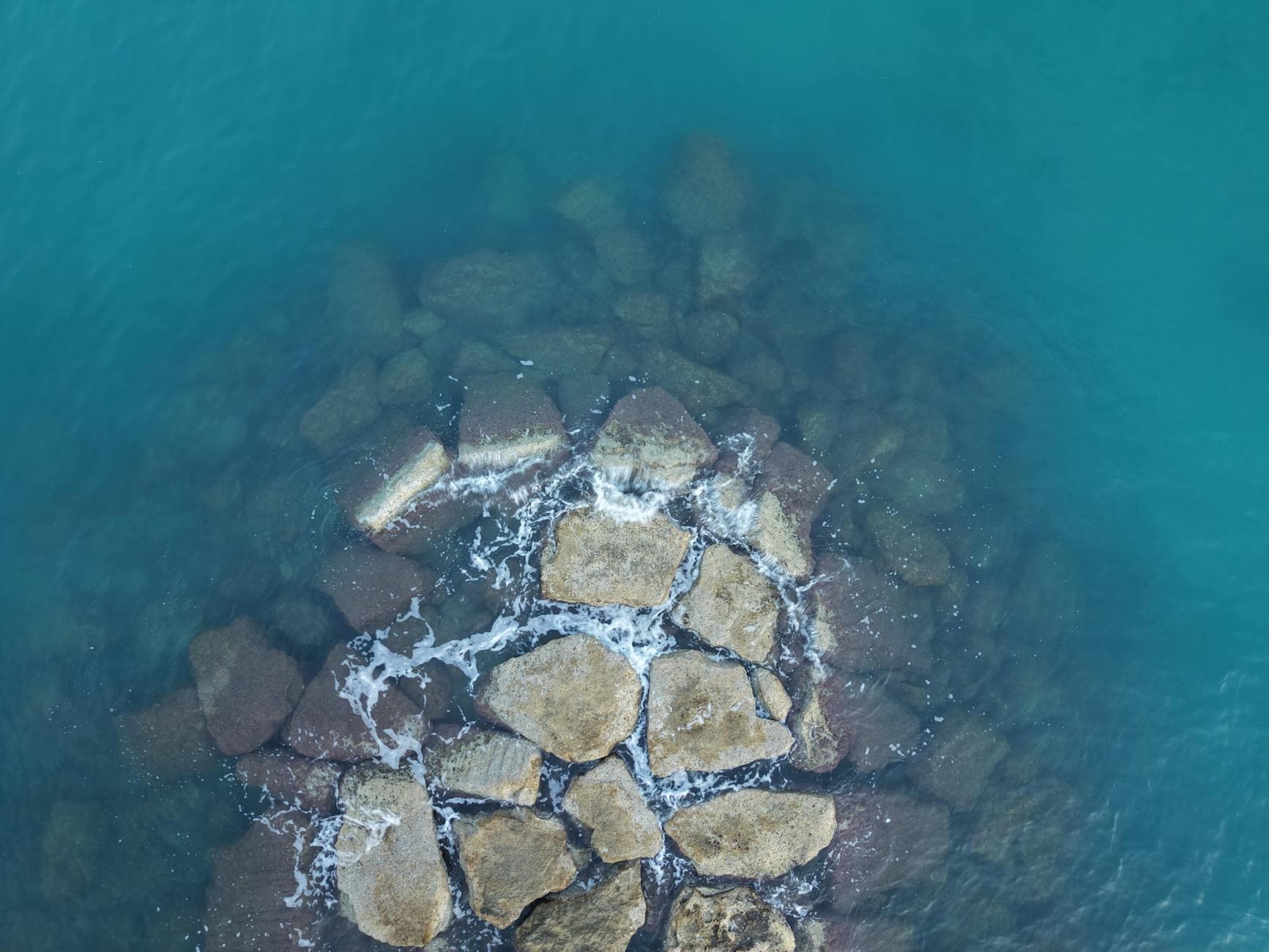 Stunning aerial view of rocks and turquoise sea near Apulia, Italy’s picturesque coastline.