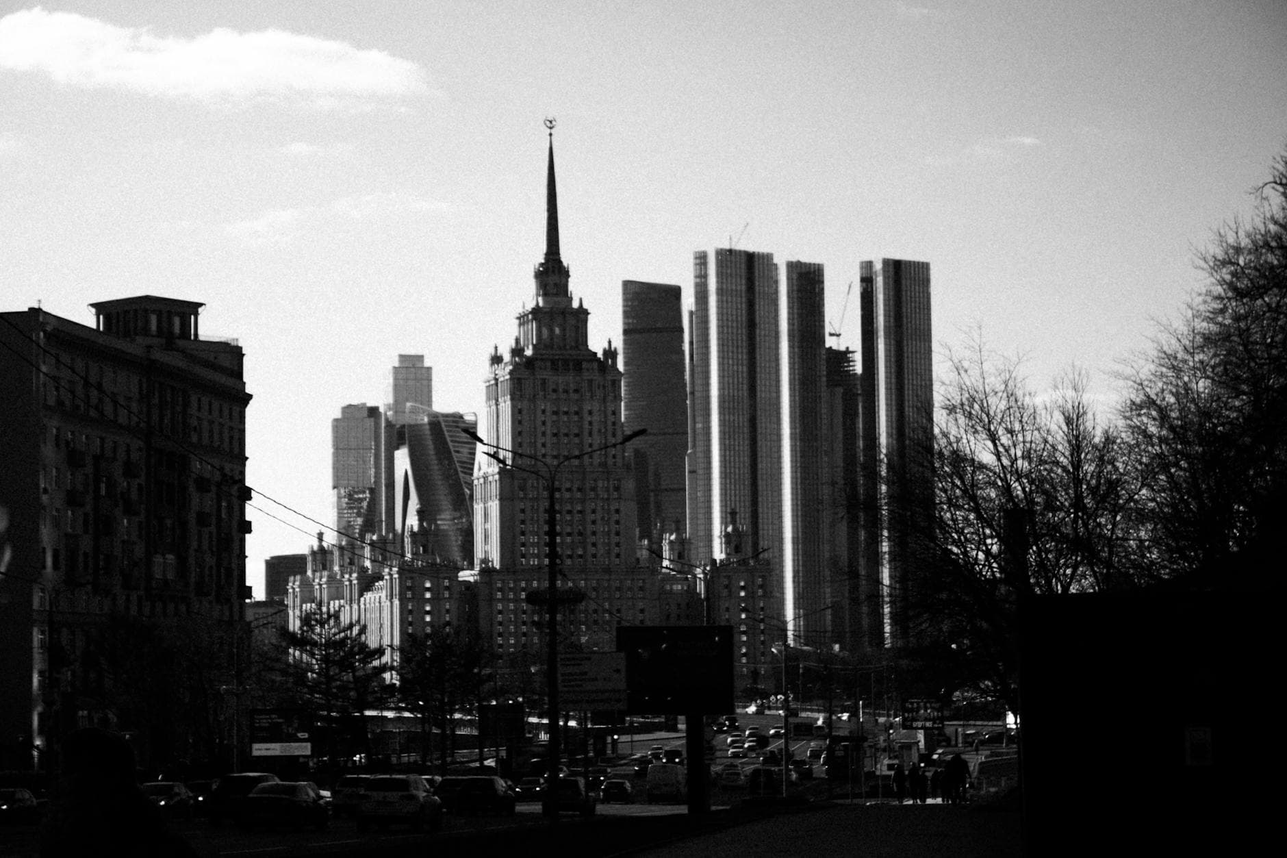 Dramatic black and white photo of city skyline with modern and historic skyscrapers.