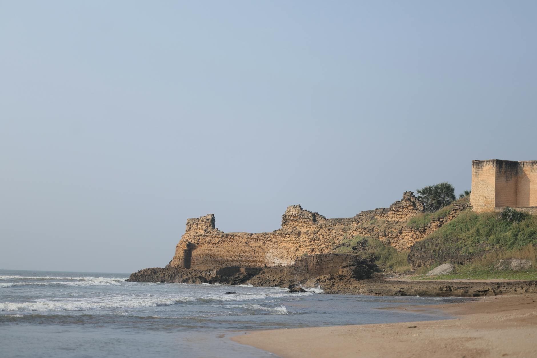 Explore the remnants of an ancient coastal fort by the sea, showcasing historic architecture and serene beach views.
