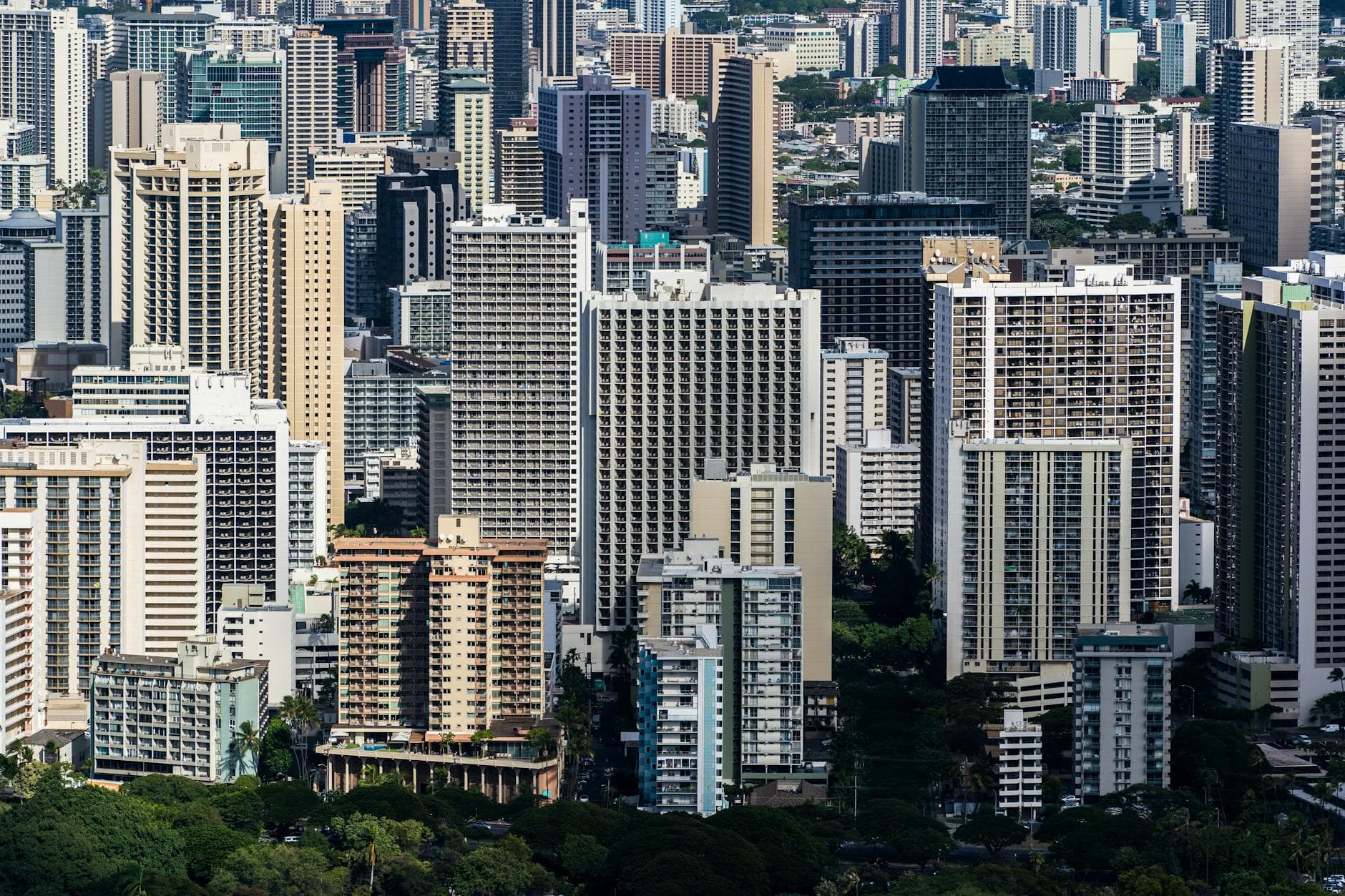Aerial cityscape of modern skyscrapers in downtown Honolulu on a sunny day.