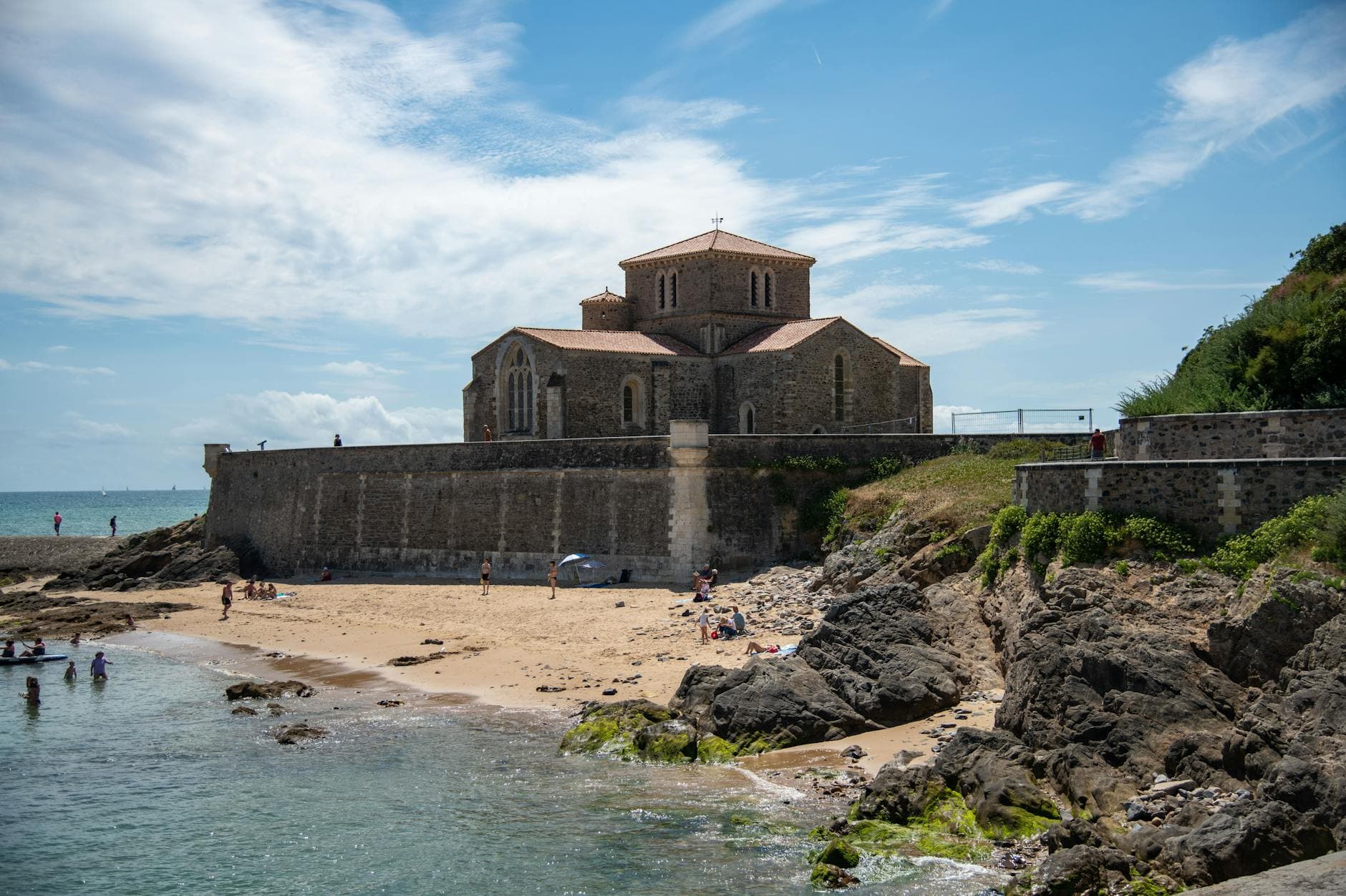 Scenic view of Prieure Saint-Nicolas church by the beach in France, under a blue sky.