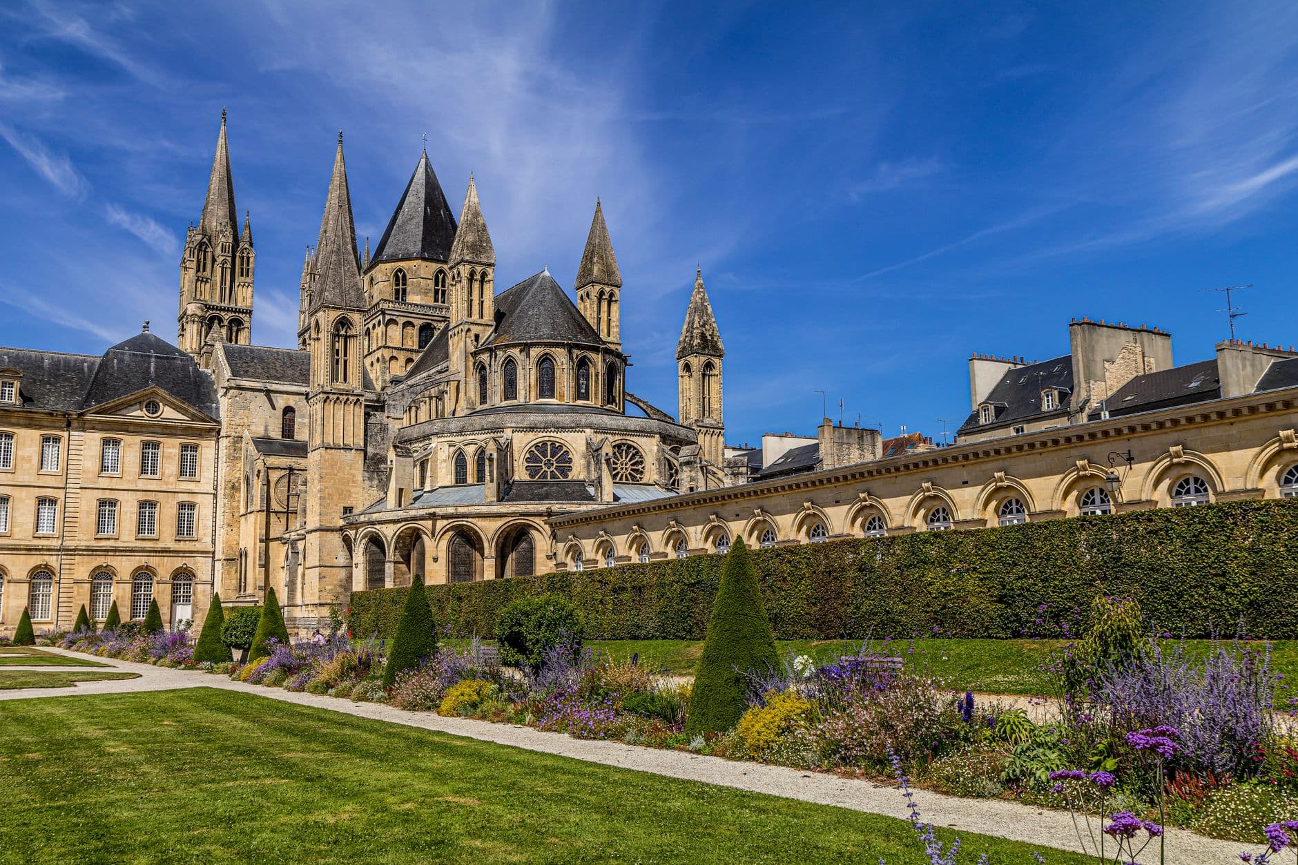 Stunning view of the historic Saint-Étienne Abbey in Caen, France, featuring lush gardens.