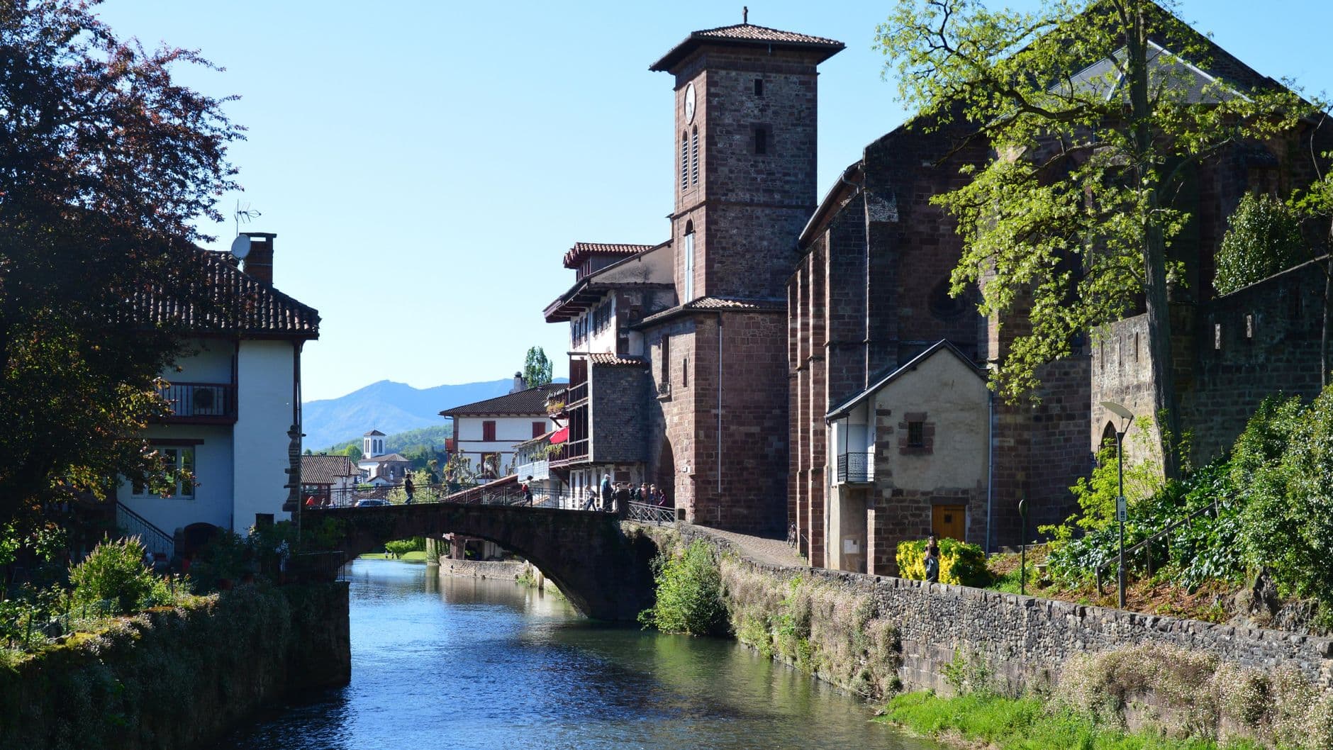 Picturesque view of Saint-Jean-Pied-de-Port with a canal and historic architecture.