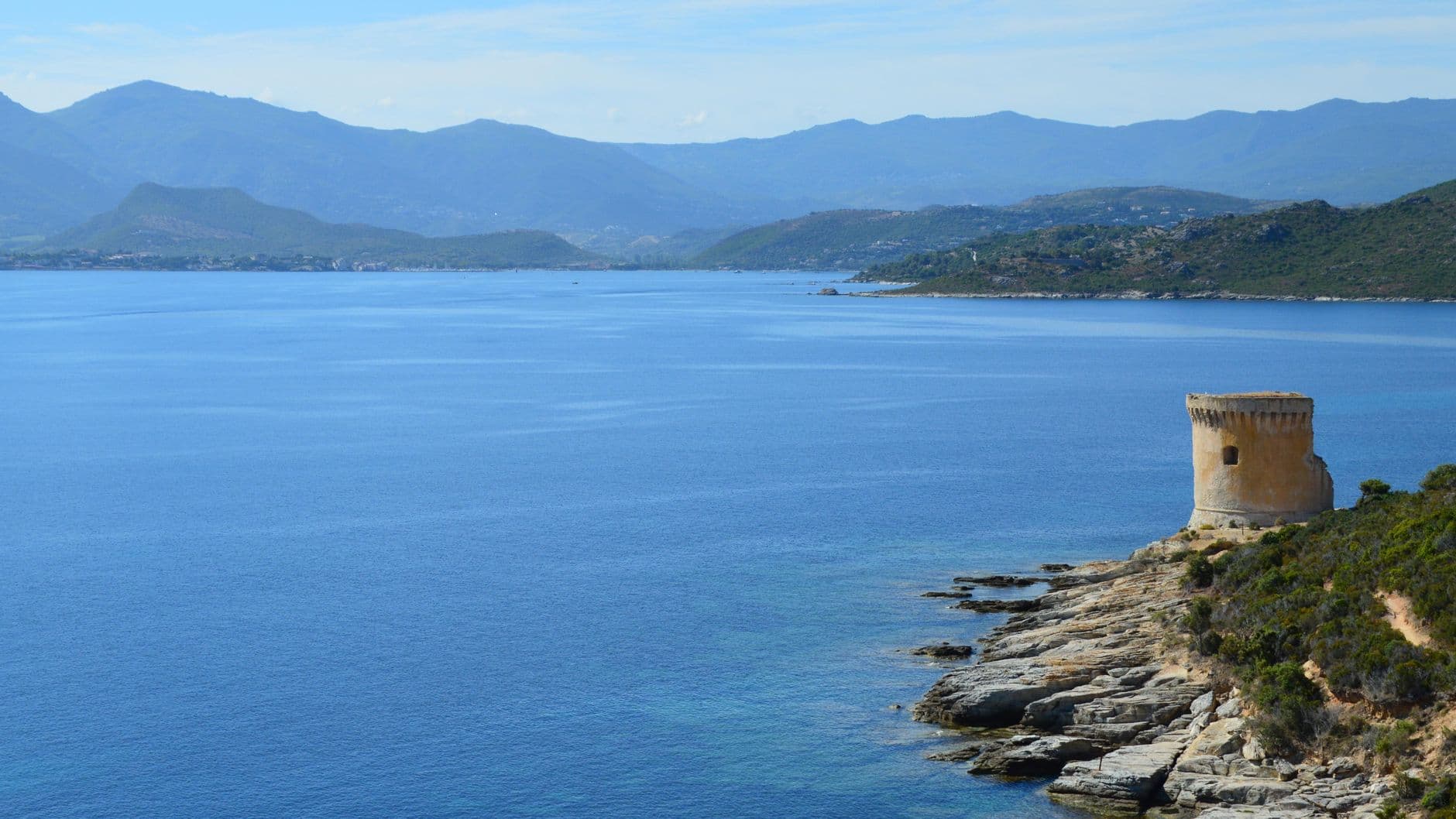Captivating view of a coastal tower and blue sea in Saint-Florent, Corsica, France.