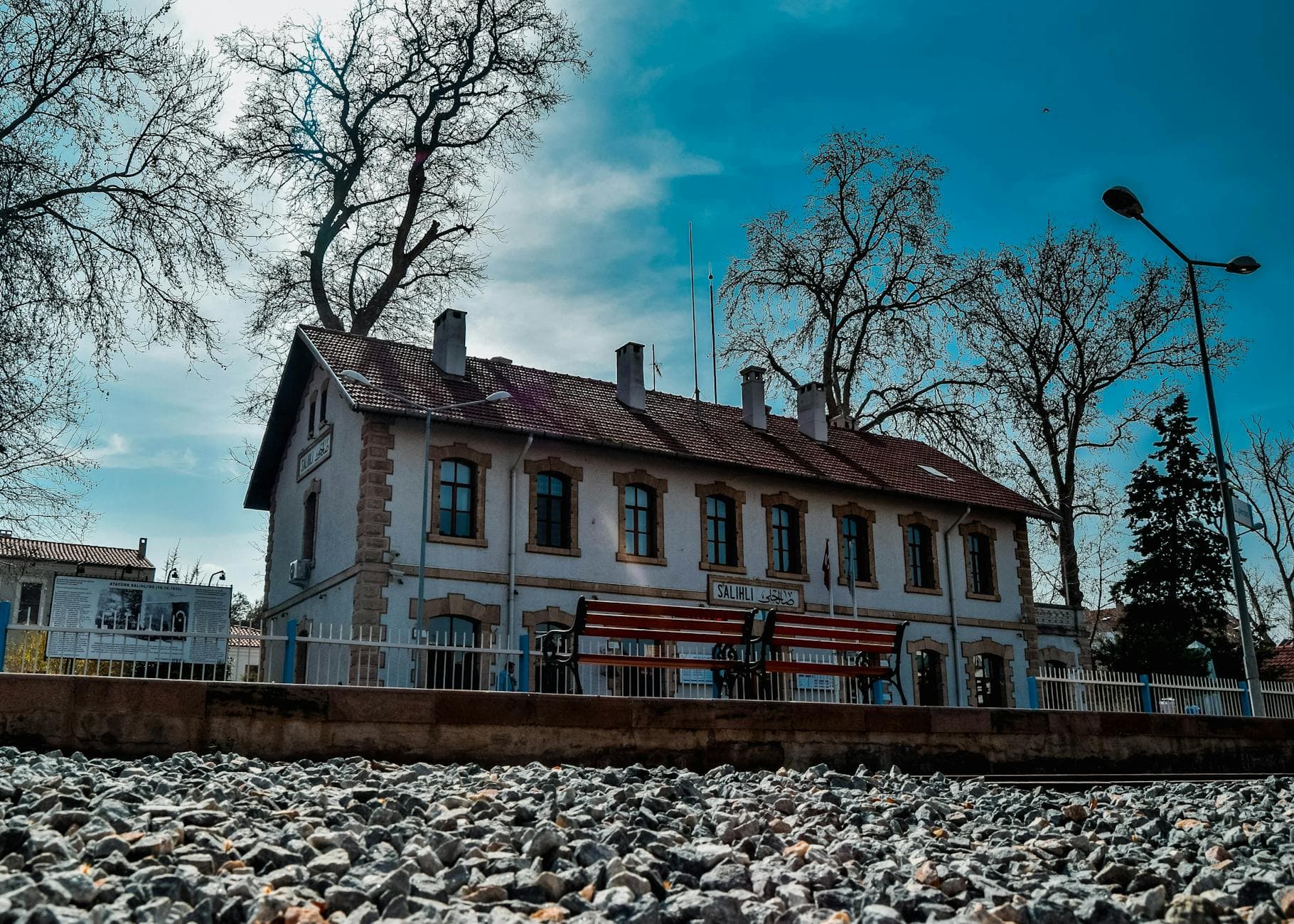A scenic view of a historic train station in Manisa, Turkey, showcasing architectural charm.