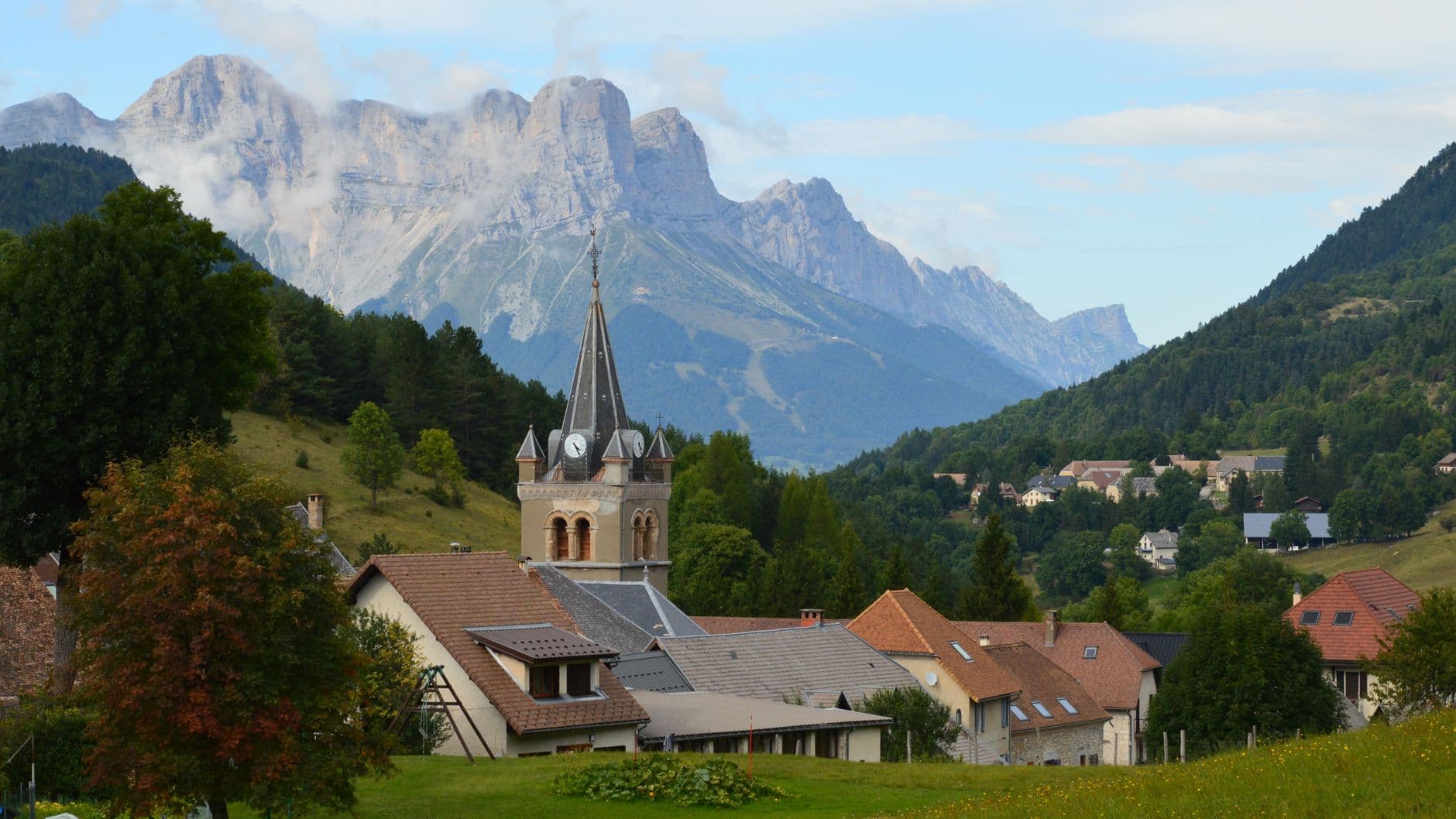 Charming village view with church and mountain backdrop in Gresse-en-Vercors, France.
