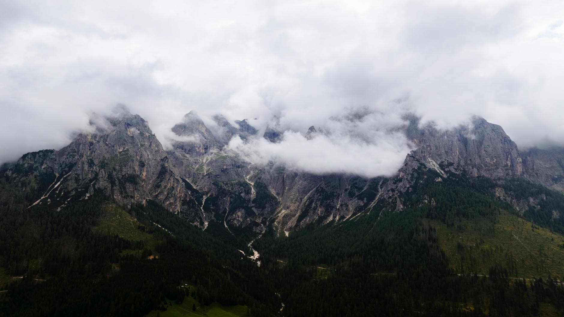 Dramatic view of cloud-covered peaks in San Martino di Castrozza, Italy.