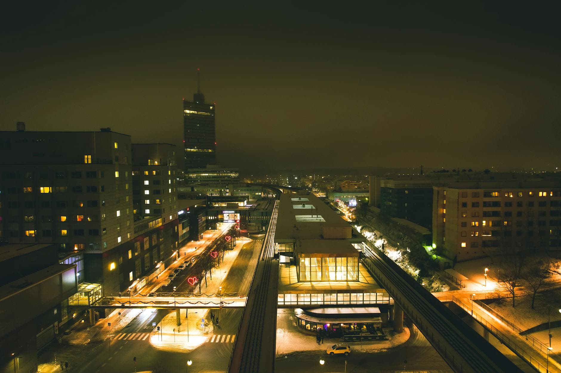 Captivating aerial night view of a Swedish urban cityscape with modern buildings and glowing streetlights.