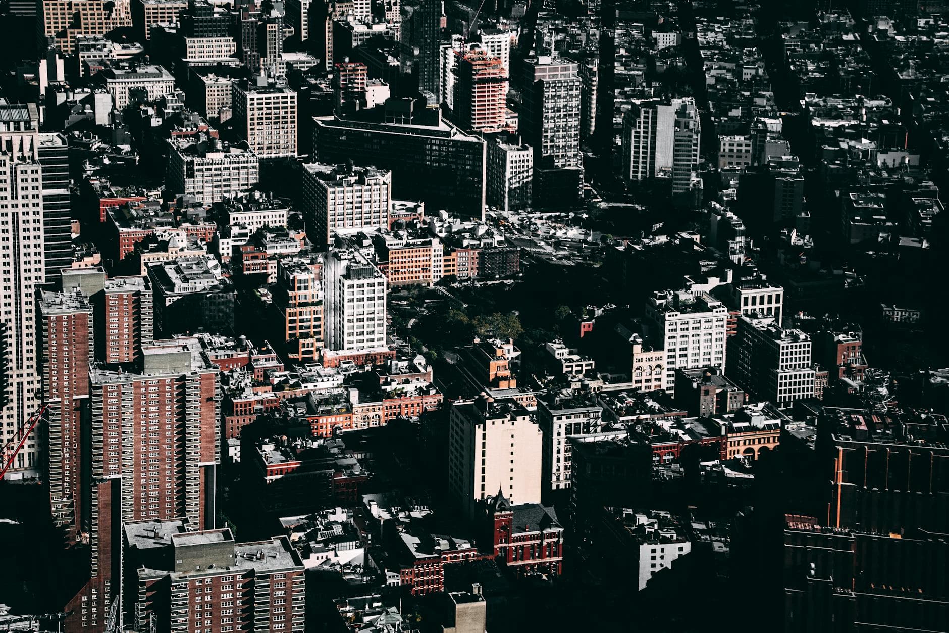 A dramatic aerial view of New York City's bustling downtown skyline captured in daylight.